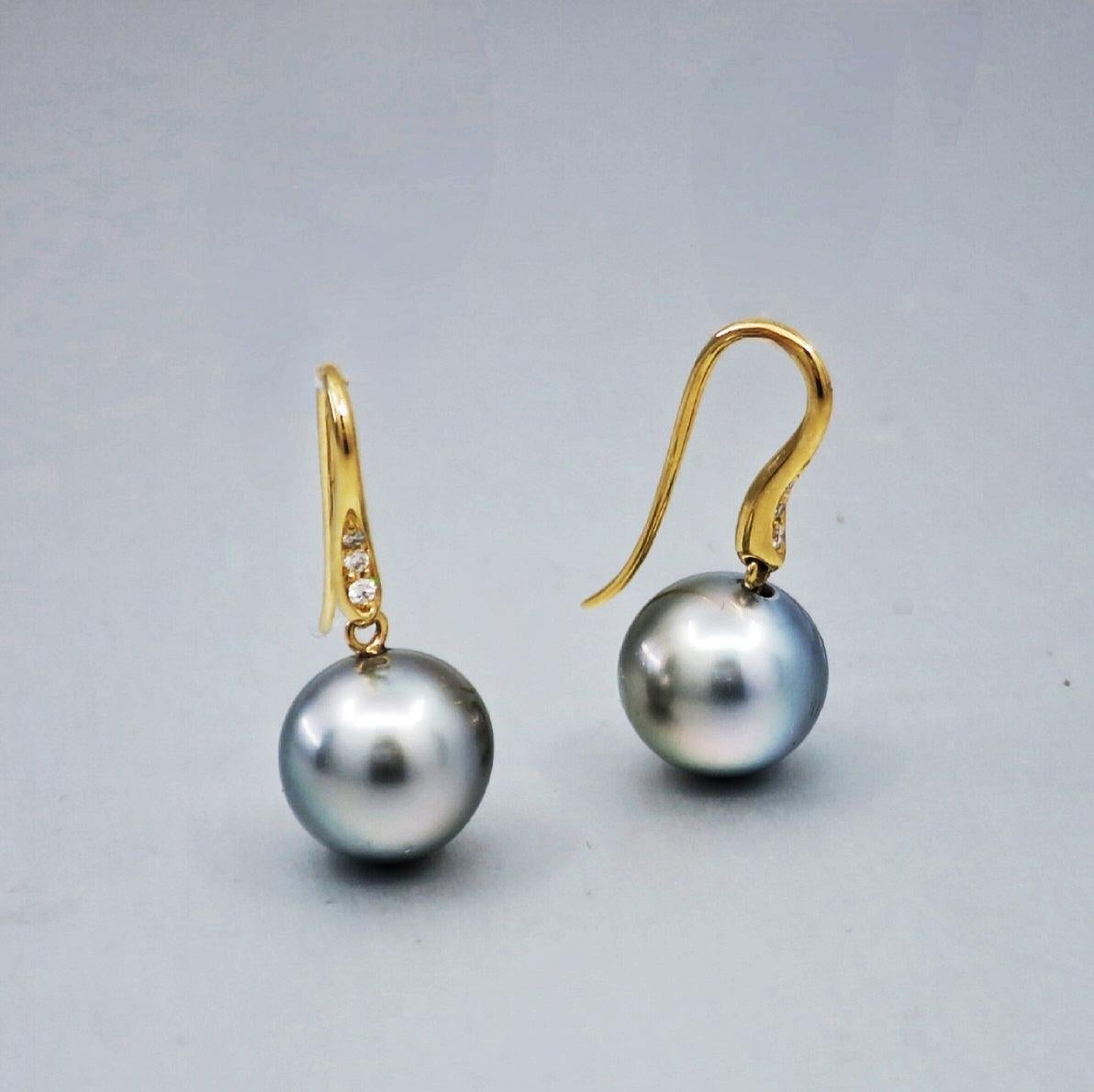 A pair of BUNDA 'Vine' Cultured Tahitian pearl earrings in 18 carat white gold, featuring drop shaped pearls of clean skin and excellent lustre, platinum grey in colour, with diamond set hook fittings.

Characteristics of diamonds: 6= 0.06ct, F