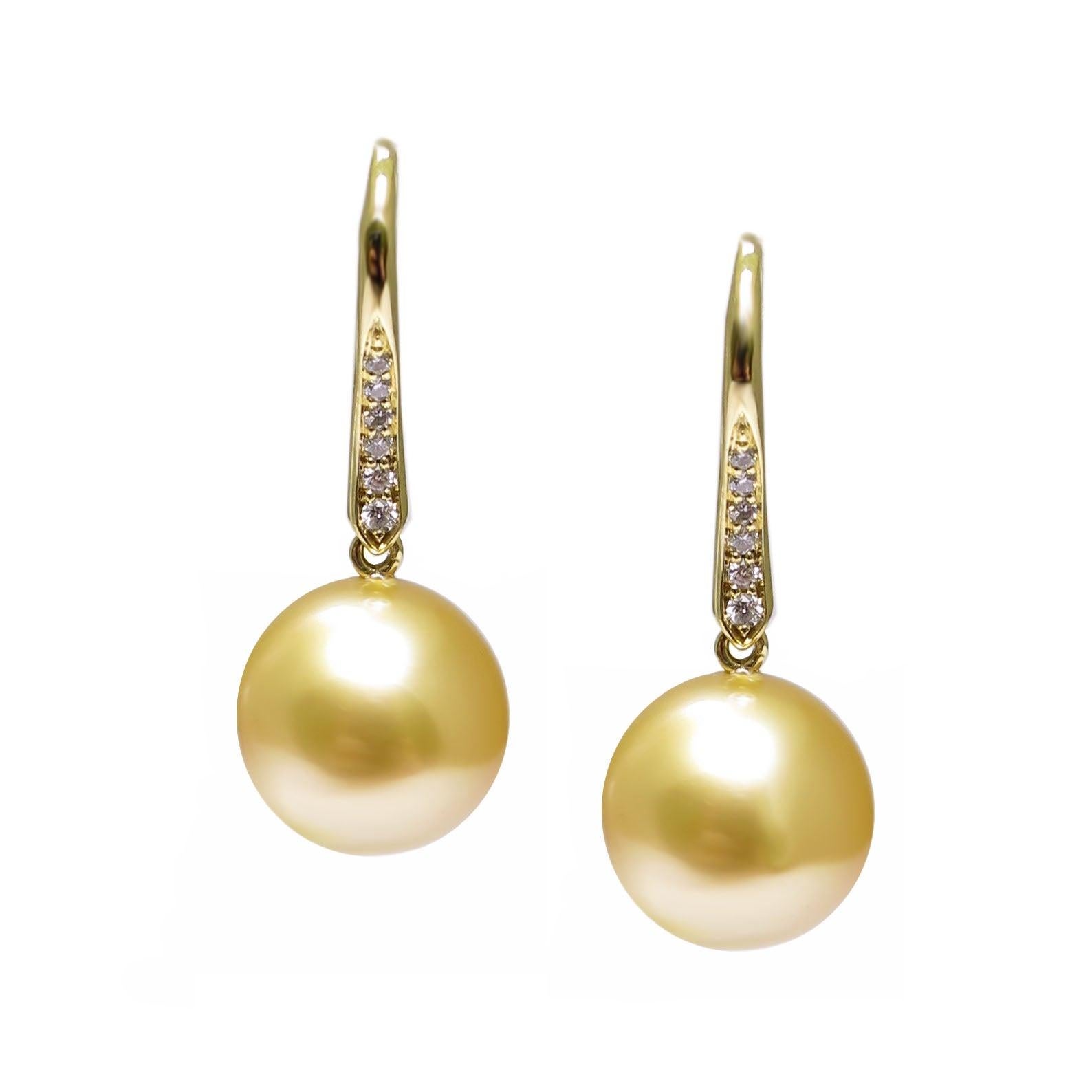 A pair of BUNDA 'Vine' Cultured South Sea pearl earrings in 18 carat yellow gold, featuring drop shaped pearls of clean skin and excellent lustre, gold in colour, with diamond set hook fittings.

Dimensions of pearls: 10.75mm

Characteristics of