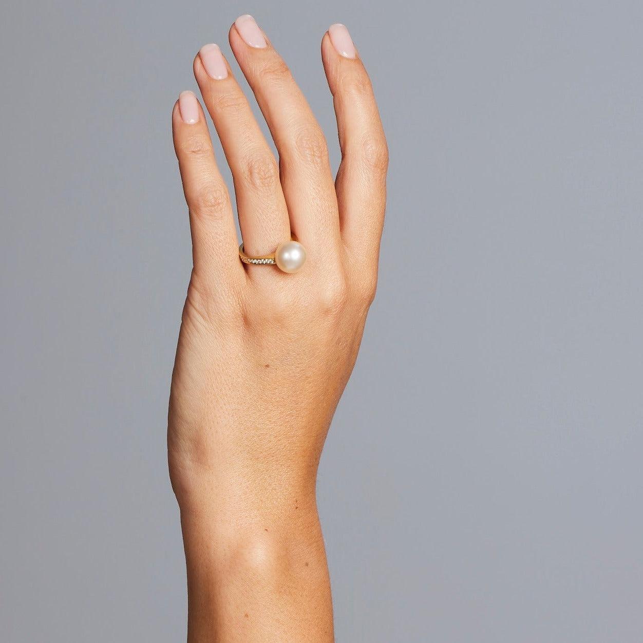 A BUNDA Cultured South Sea pearl and diamond 'Capella' ring in 18 carat yellow gold, set with a round shaped pearl of clean skin and excellent lustre, cream in colour.

Dimensions of pearl: 11.20mm

Characteristics of diamonds: 26 =0.28ct, F colour,