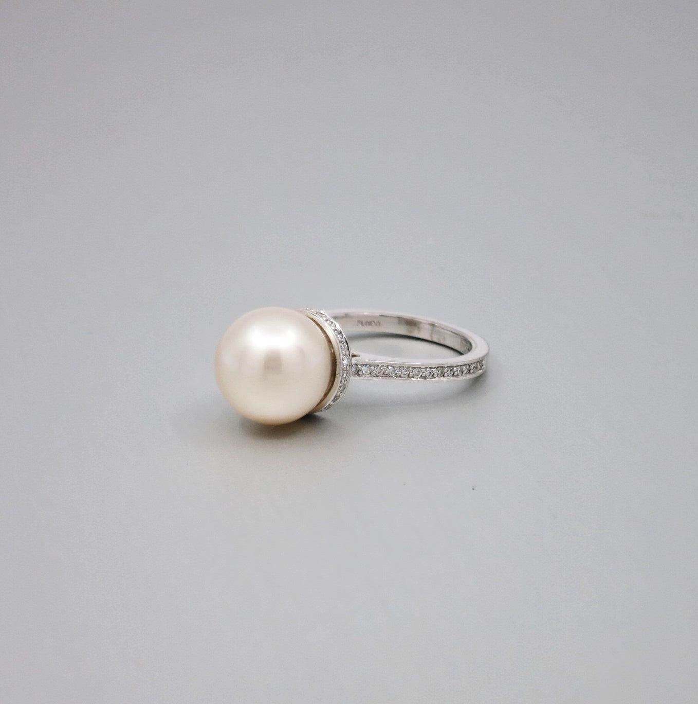 A BUNDA 'Tanara' Pearl and Diamond Ring in 18ct white gold, Signed Bunda. Size M.

Characteristics of cream South Sea Cultured Pearl; 11.6 mm.

Characteristics of Additional Round Brilliant Cut Diamonds: 50 = .25ct, F colour, VS Clarity

Weight