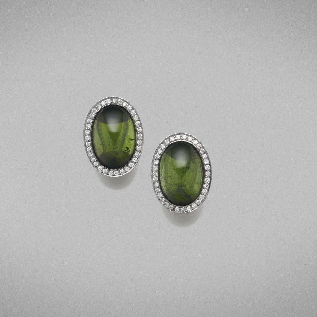 A pair of BUNDA 'Corvus' tourmaline earrings in 18ct white gold, featuring a pair of cabochon cut green
tourmalines, bezel set and surrounded with threadset round brilliant cut diamonds, fitted with a post and
keyhole clip fitting.
Characteristics