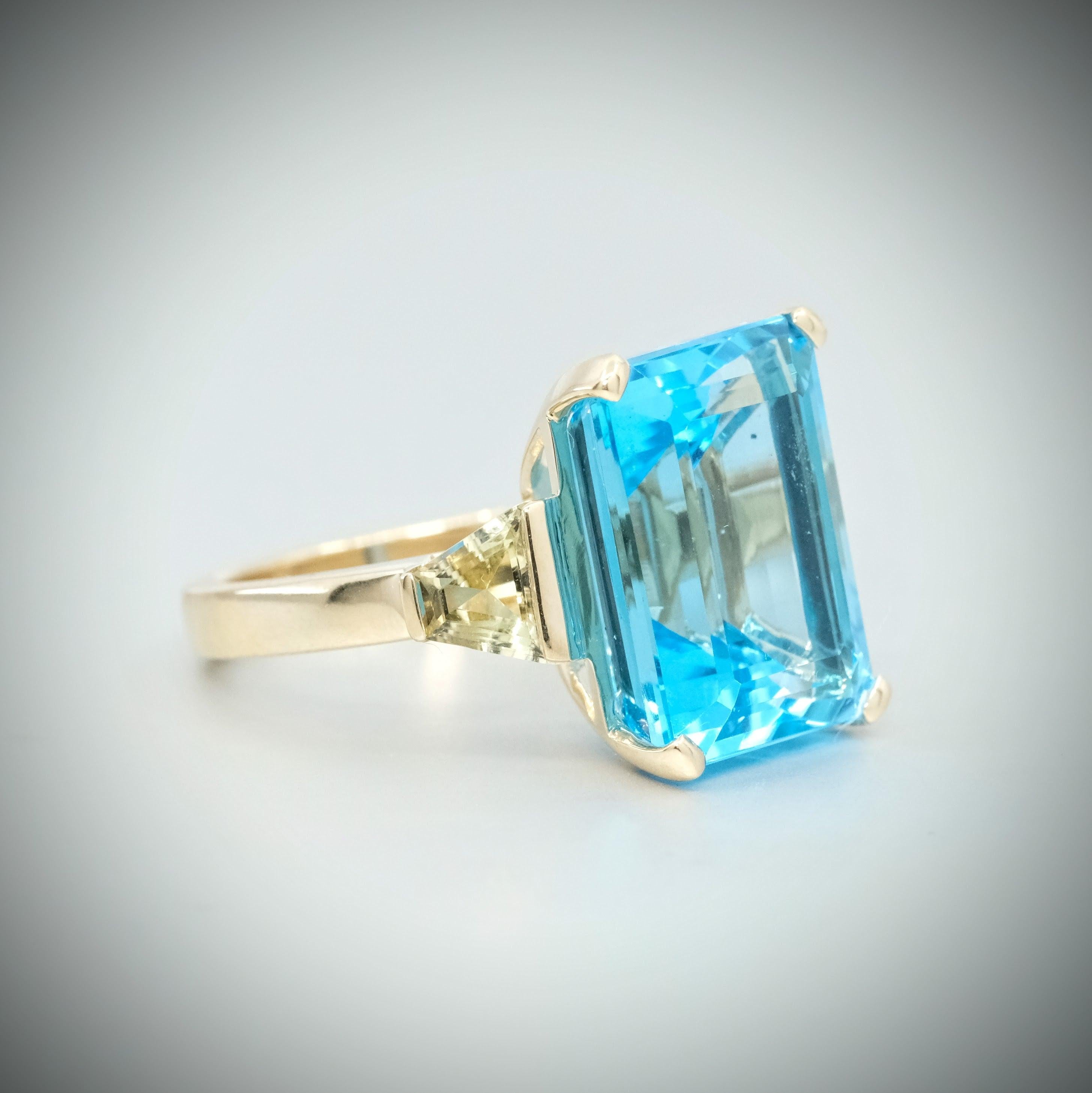 Anillo BUNDA Volans de topacio y turmalina, engastado en oro amarillo de 18 ct. Firmado BUNDA.
Características del topacio azul talla esmeralda; 1 = 15,36 ct. 

Características del Cuarzo Amarillo talla trapecio; 1 = 0,52ct. 

Características del
