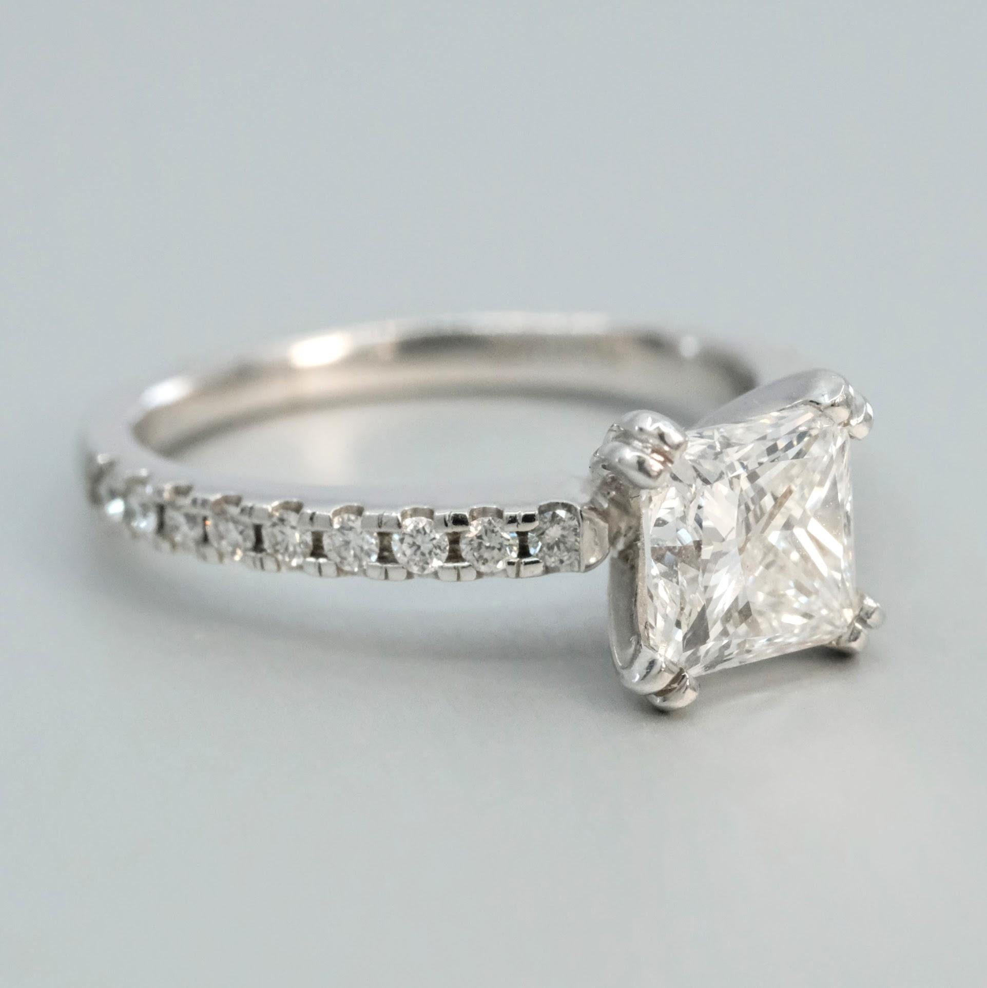 A BUNDA 'Mignon' diamond ring in platinum, set with a princess cut diamond and round brilliant cut side diamonds.


Characteristics of centre diamond: 1 = 1.61ct, G colour / SI1 clarity.

Characteristics of additional diamonds: 18 = 0.24ct, F/
