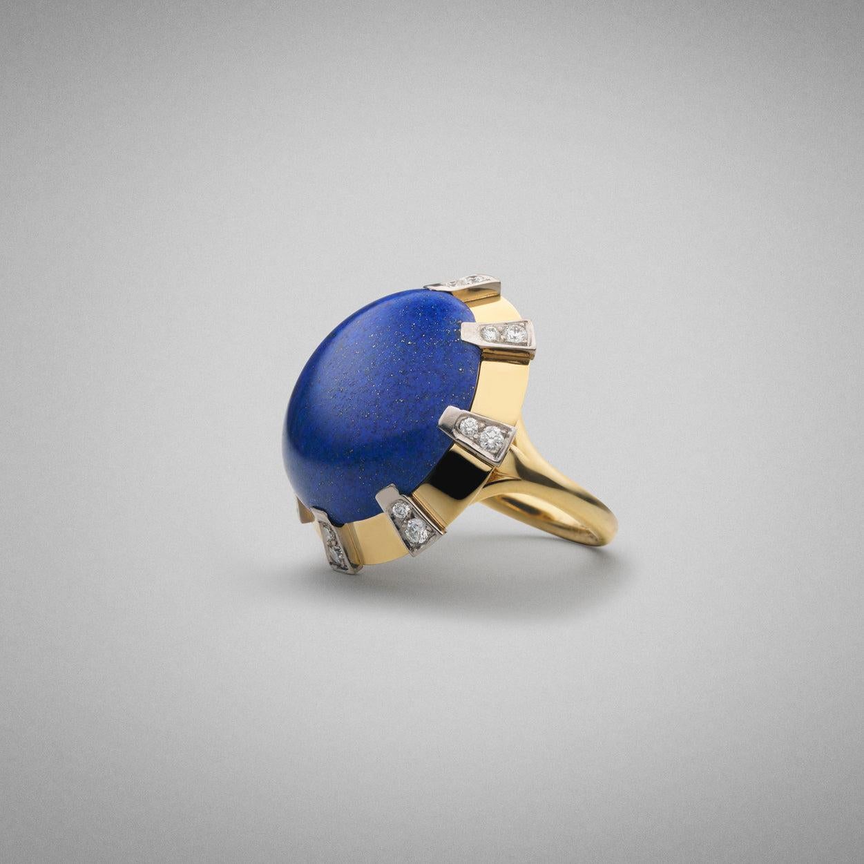 Anello BUNDA Apus Lapis Lazuli. Oro bianco e giallo 18ct. Anello taglia M 1/2.
Caratteristiche del Lapis blu tagliato a cabochon; 1 = 18,54ct.
Caratteristiche dei diamanti taglio Brilliante Rotondo: 16 = .27ct, colore F, purezza VS
Peso totale: