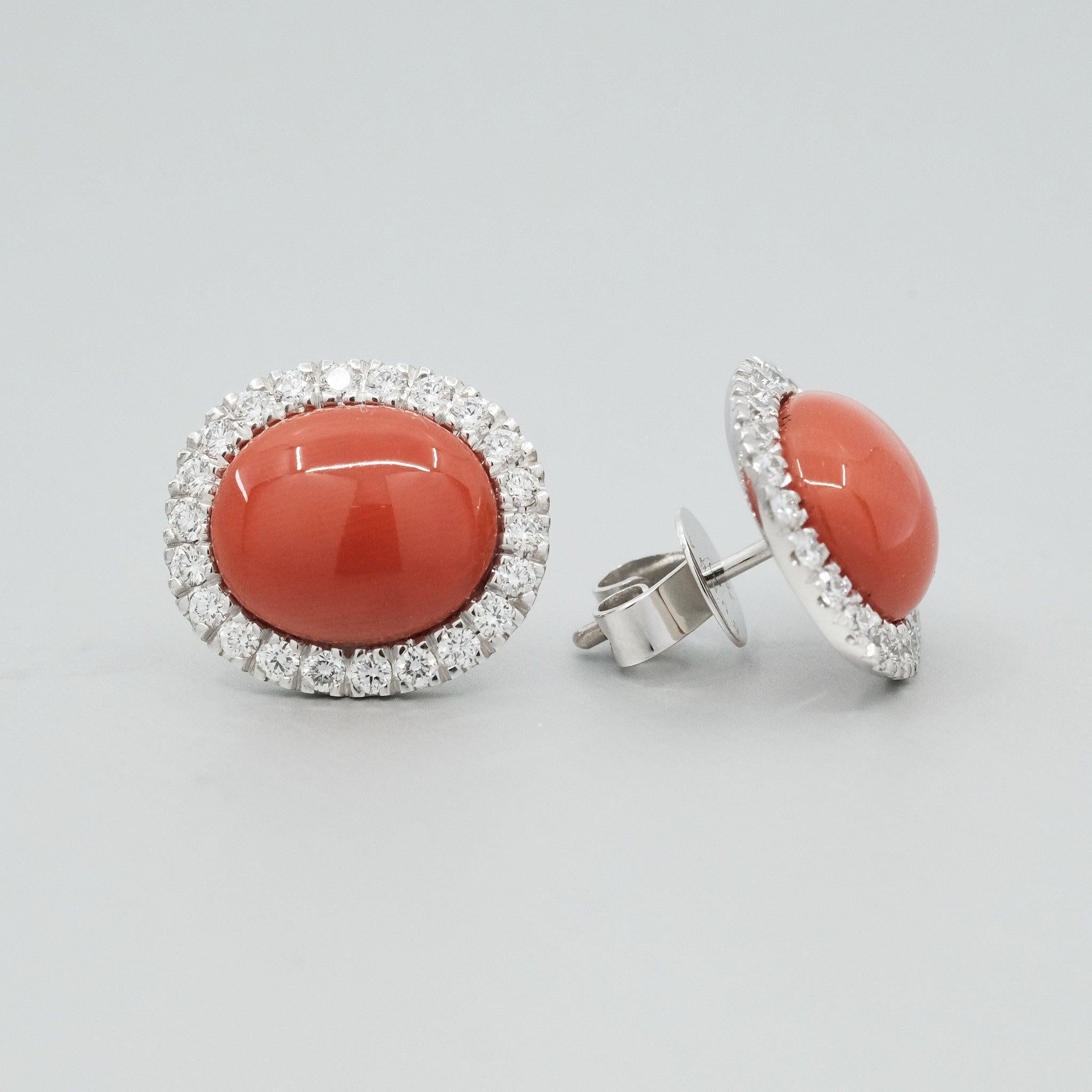 A pair of BUNDA 'Valentin' Precious Coral Earrings in 18ct white gold. Each earring is set with an oval cabochon of natural precious coral with castle-set round brilliant diamonds to the head.

Fittings are post and butterfly in 18ct white