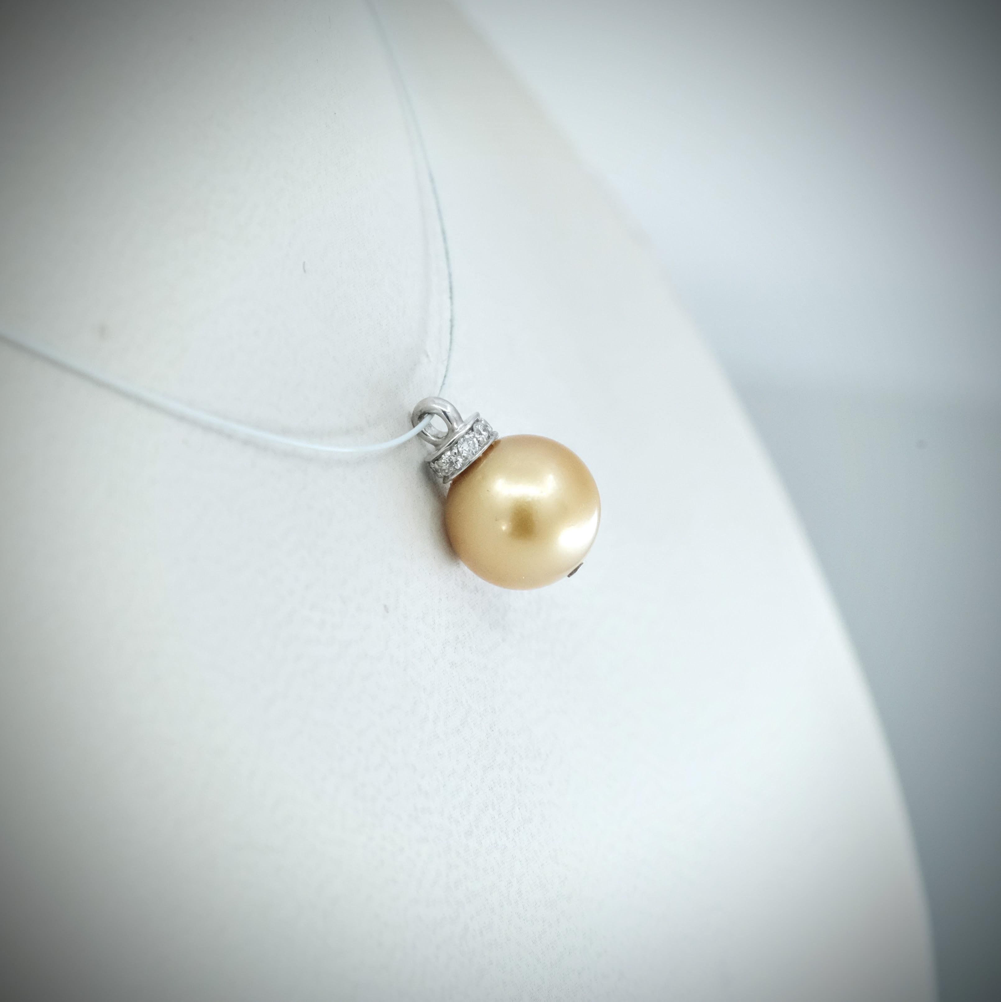 A BUNDA Cultured South Sea pearl and diamond 'Dorado' pendant in 18 carat white gold, featuring a round shaped pearl of clean skin and excellent lustre, gold in colour, fitted with a diamond set cap.

Dimensions of pearl: 9.50 -