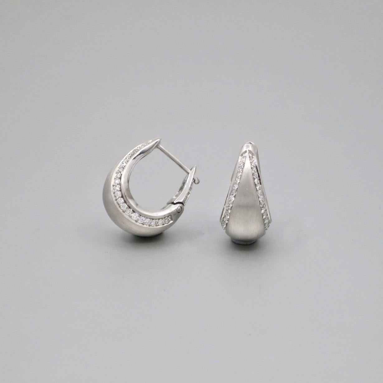 Paire de boucles d'oreilles BUNDA 'Bundova' Diamond clip earrings en or blanc 18ct. Chaque boucle d'oreille est sertie de diamants ronds de taille brillant sur les bords. Les boucles d'oreilles ont une finition brossée.

Caractéristiques des