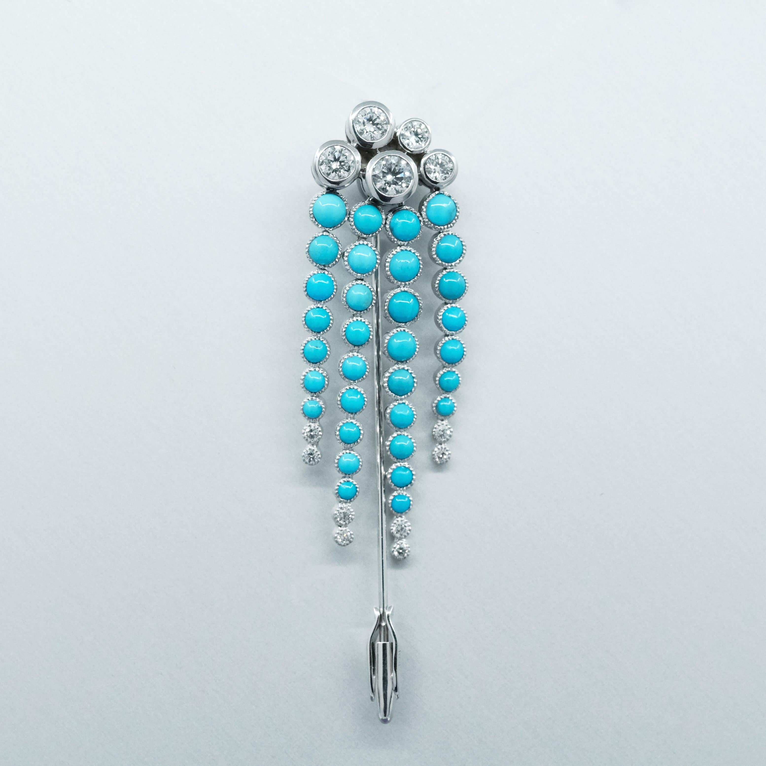 A BUNDA 'Couture' handcrafted turquoise and diamond brooch made in 18 carat white gold, featuring a cluster of 5, round brilliant cut diamonds, all bezel set and finished with millegrain detail. Suspended from the diamond cluster are 4 lines of