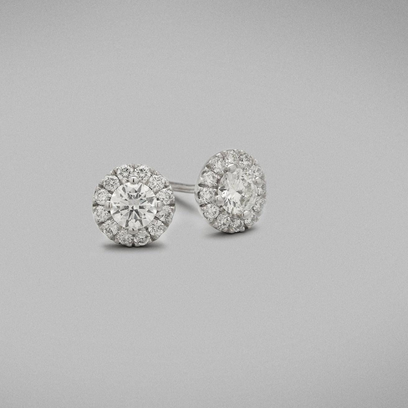 A pair of BUNDA 'Valentin' Diamond Stud Earrings in 18ct white gold. Each earring has a round brilliant
diamond in a four claw setting at the centre and castle set round brilliant diamonds to the head. Fittings are
post and