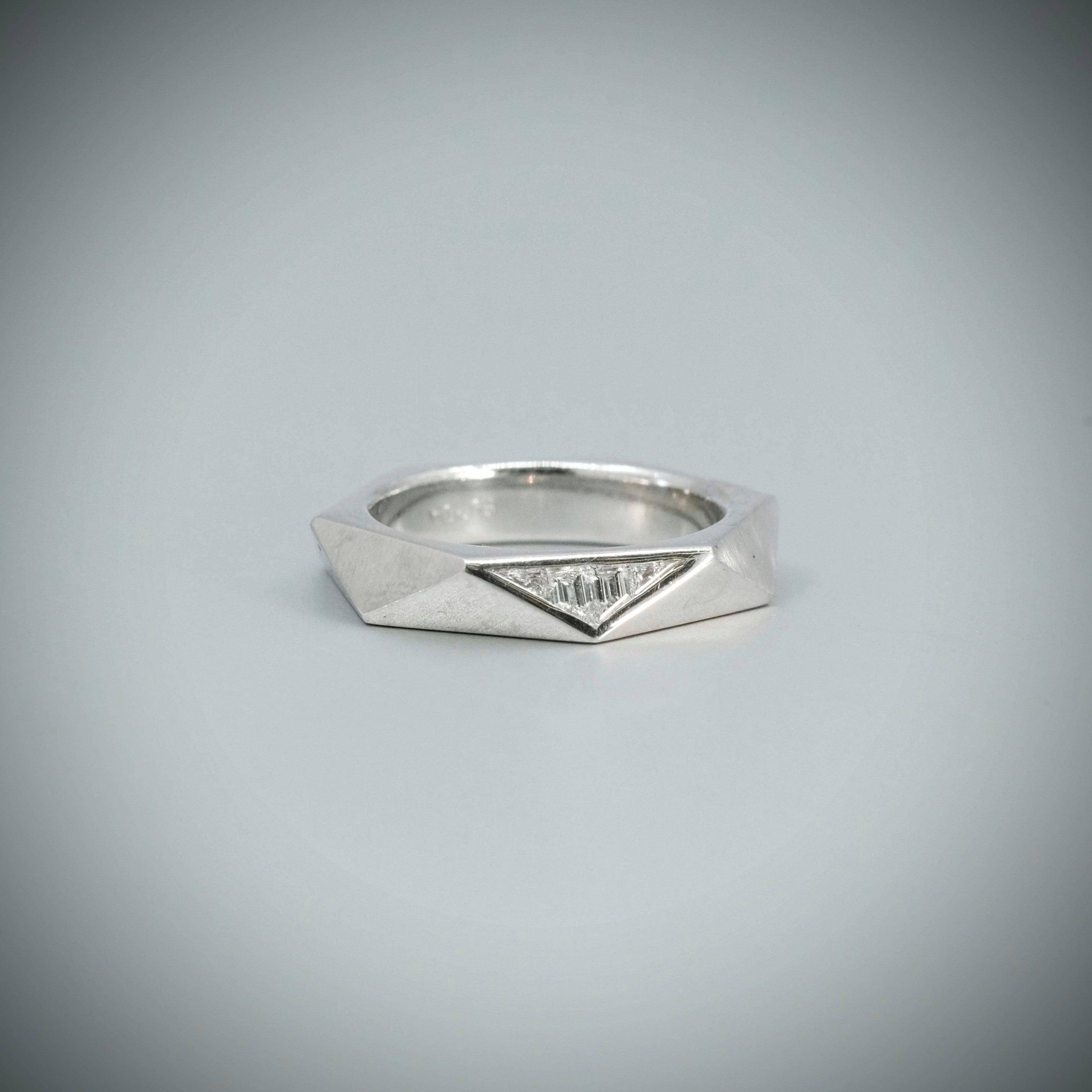 A Couture Facet diamond ring, with four tapered baguette diamonds totalling 0.17ct (colour F, clarity VS), set in platinum, with polish and brushed finish.

Signed BUNDA.

Size N.