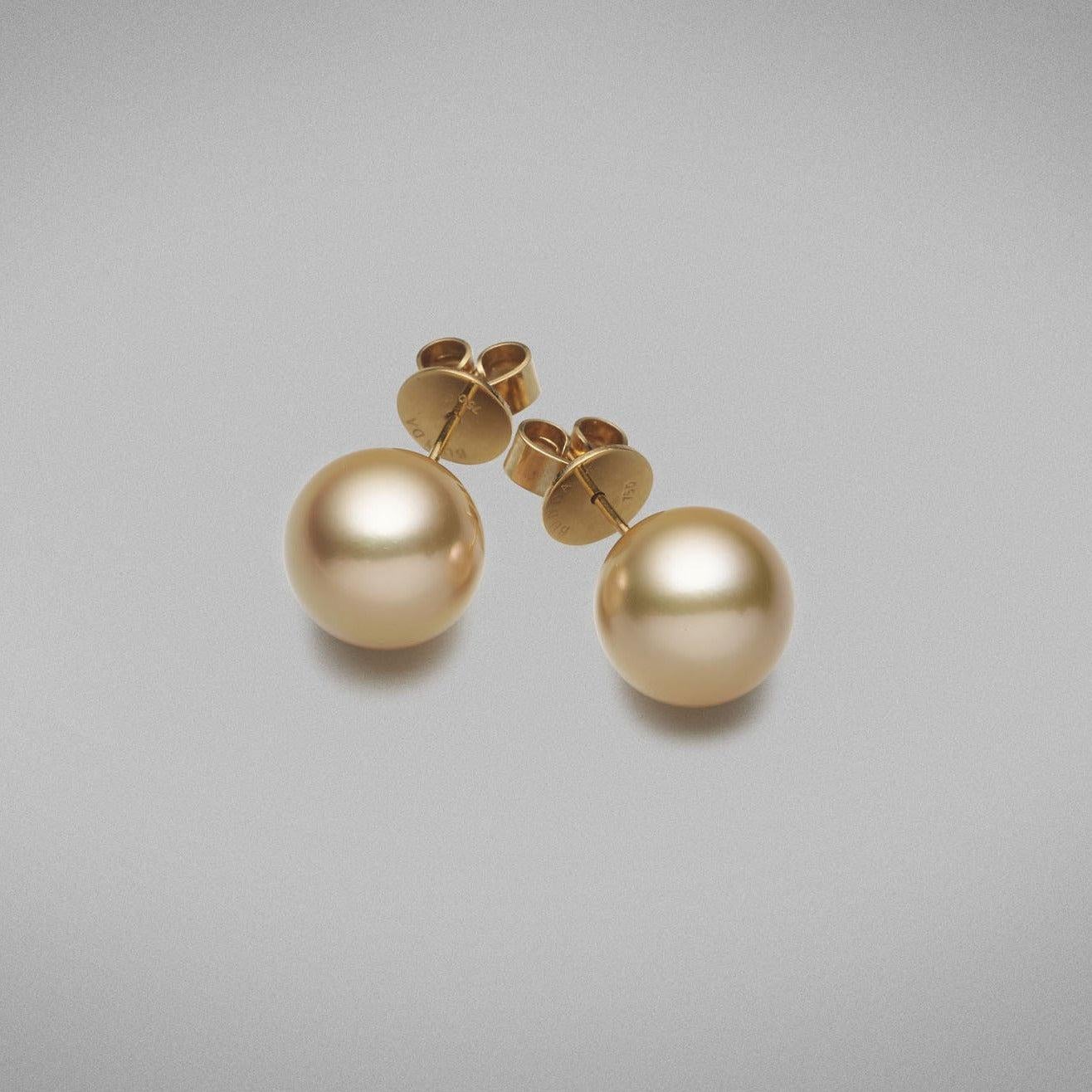 A pair of BUNDA Cultured South Sea pearl stud earrings in 18 carat yellow gold, set with round shaped pearls of clean skin and excellent lustre. 
The pearls are an intense deep golden colour and measure approximately 12.90mm. 
Fittings are post and