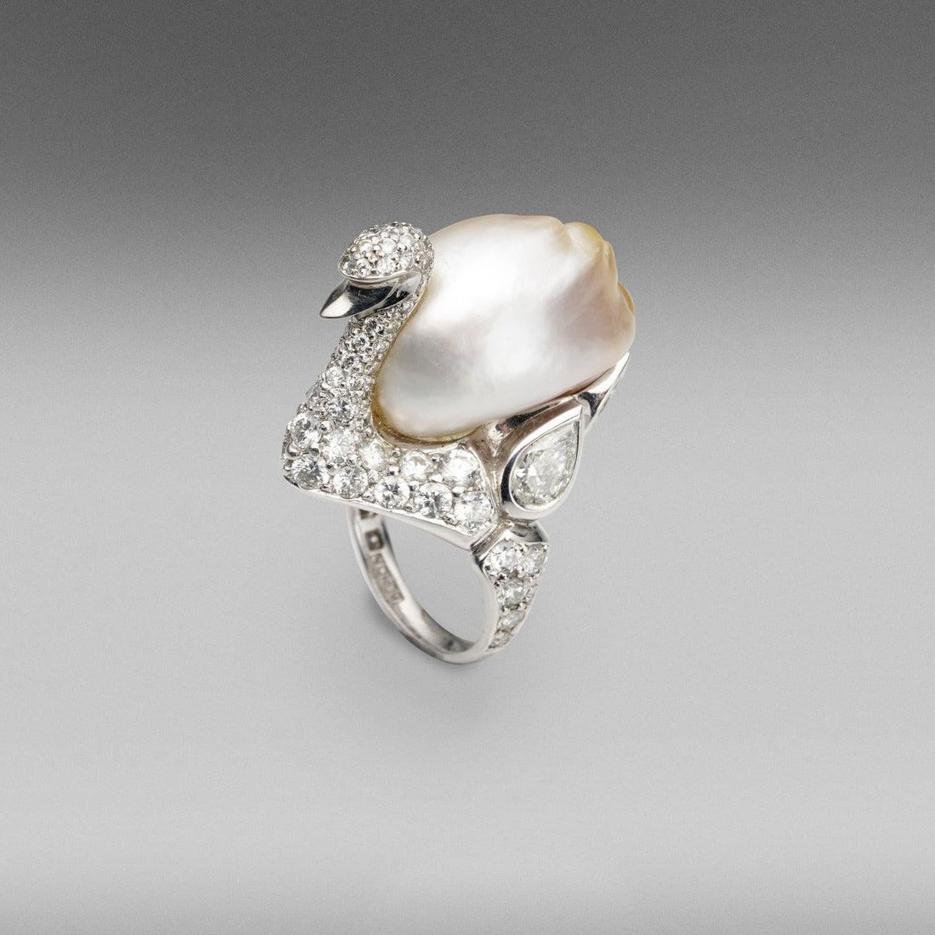 A BUNDA 'Swan' ring in platinum, featuring an exquisite, baroque Cultured South Sea Keshi Pearl, champagne in colour with a clean skin and an excellent lustre. The Swan itself features a round brilliant cut diamond pave set body with bezel set pear