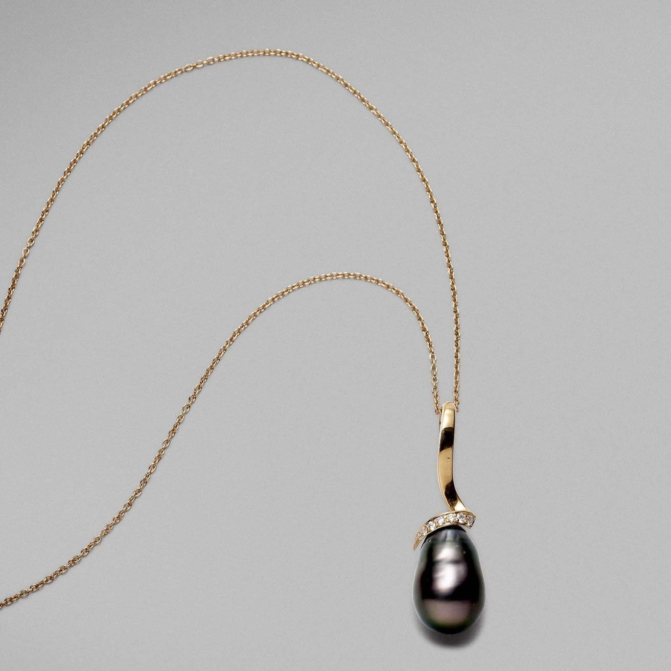 Pendentif BUNDA 'Lyra' en or jaune 18ct. Le pendentif est serti d'une perle Keshi de Tahiti, de forme baroque, de couleur paon avec des nuances aubergines, avec une peau claire et un excellent lustre. La monture 'Lyra' est sertie de diamants ronds