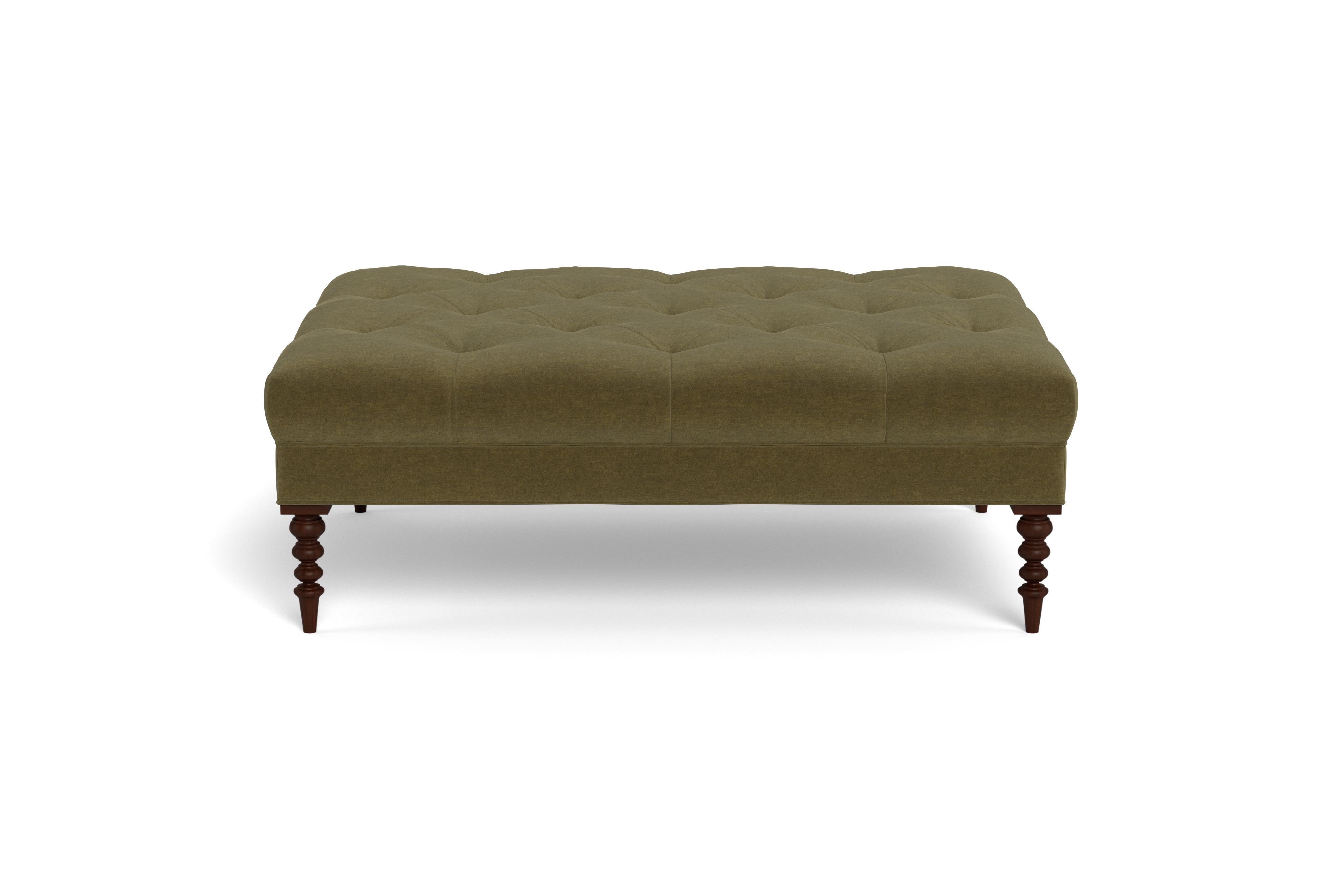 A large cocktail ottoman, with beautiful tufting set atop a trim upholstered box, with wonderfully turned legs. Made to order in a neutral olive velvet, a fabric able to be cleaned and used in high traffic areas.  Legs finished in mahogany.  Returns