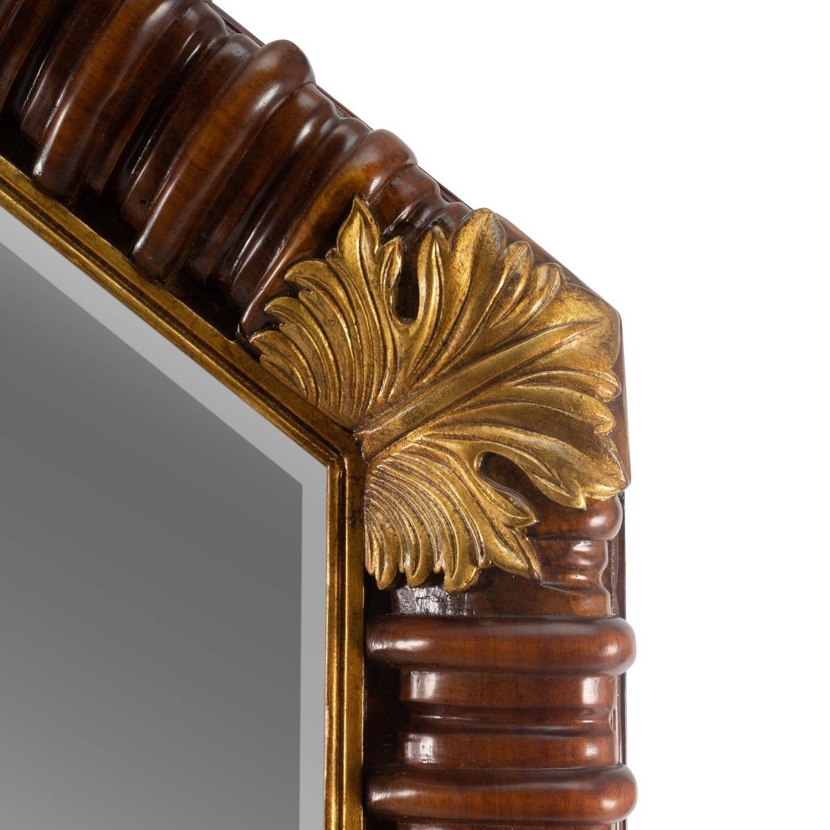 The acanthus mirror by Bunny Williams Home, measuring over four-feet tall, features an octagonal-shaped frame with a hand-applied medium mahogany finish and is adorned with carved, gilded acanthus leaves.

Features:
Hand carved