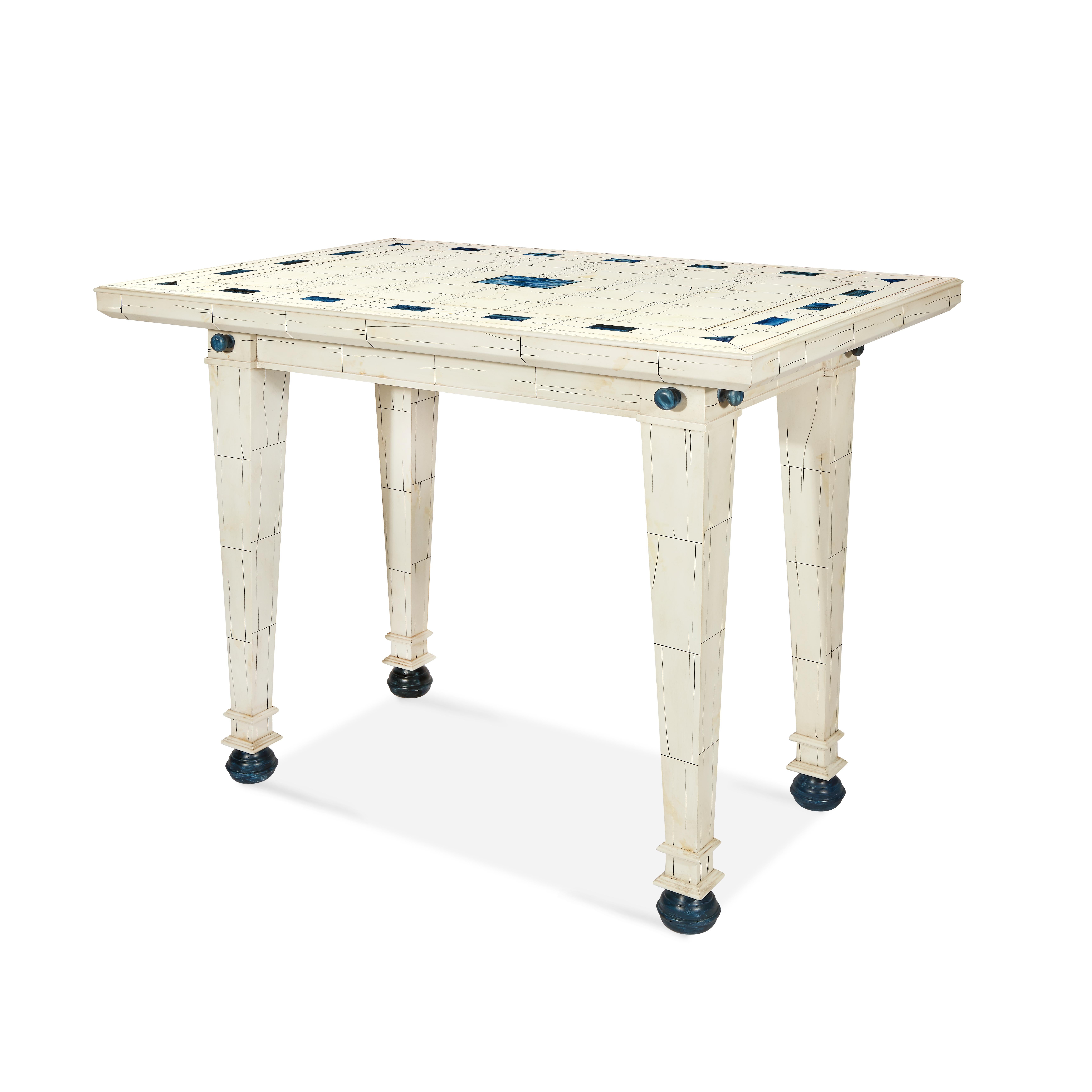 A faux painted ivory and lapis lazuli table, with its masterful brushwork, clean palette of whites, blues and blacks, is equally at home in contemporary or traditional rooms. Tapered legs with bun feet.
