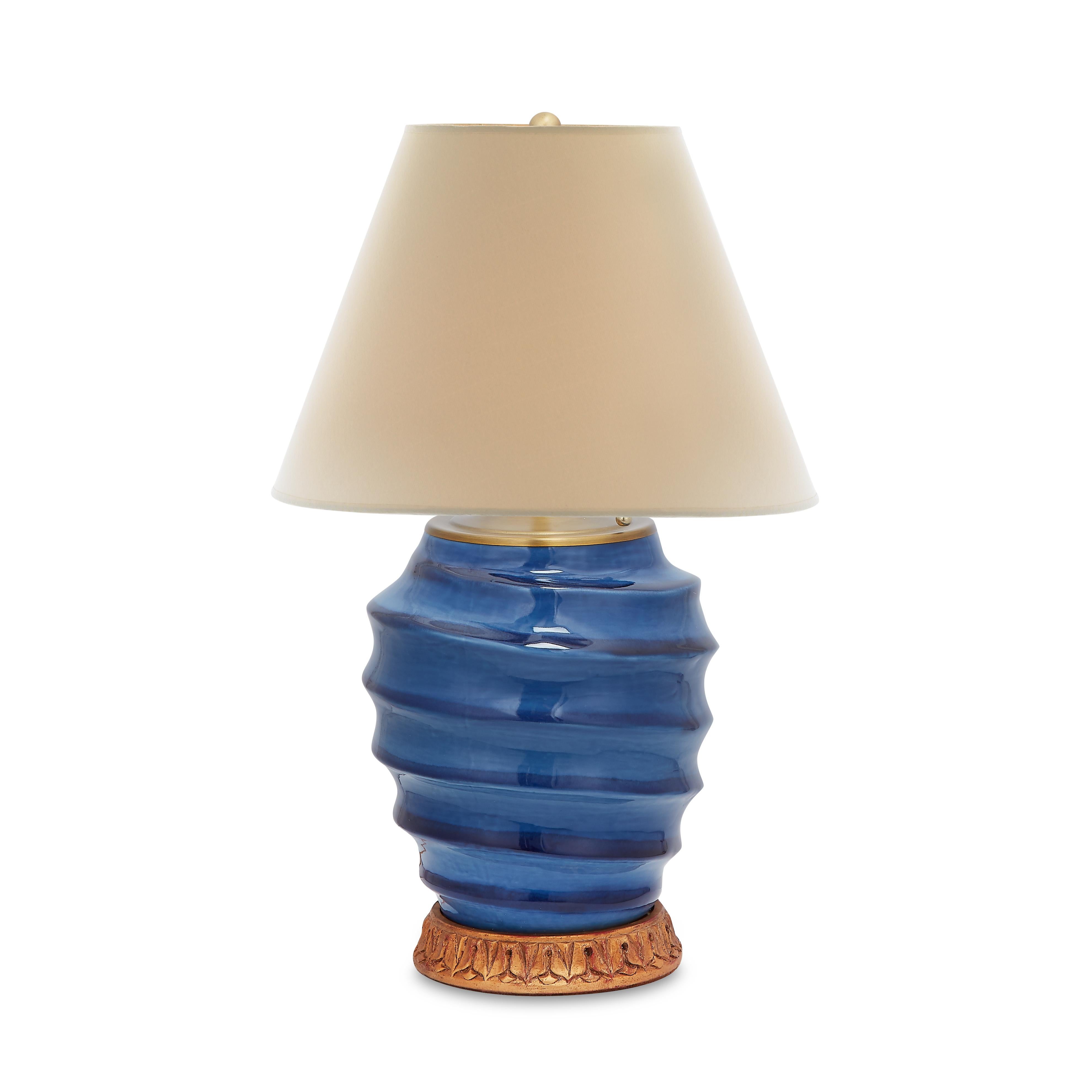 Eine auffällige geometrische Spirale hebt die dunklen und hellen Töne der fröhlichen atlantischen blauen Glasur hervor, die Namensgeberin dieser wohlproportionierten Lampe ist. Auf einem Sockel aus vergoldetem Gold.