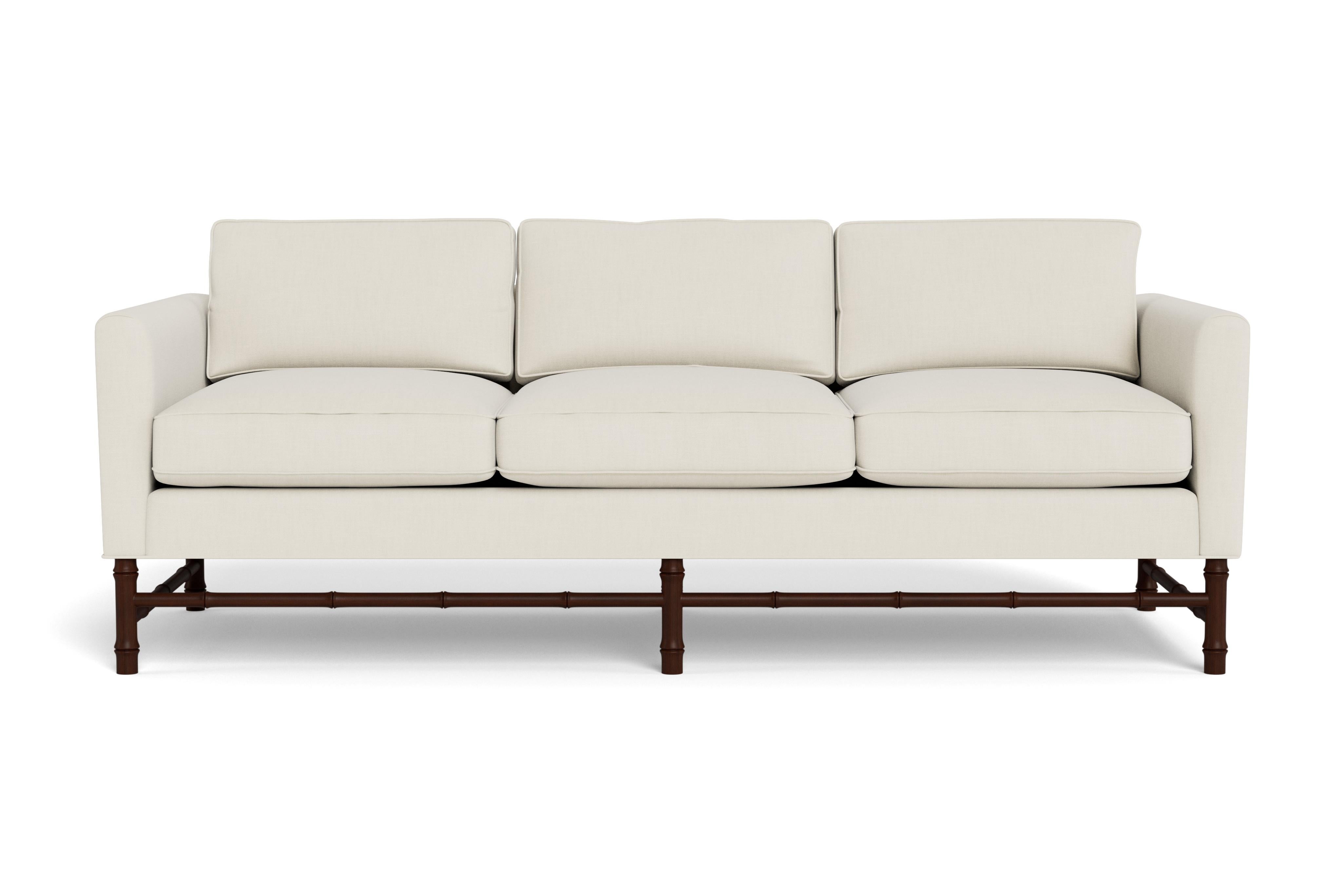 Ce canapé confortable présente des lignes classiques et épurées, mais sa base en bambou lui donne de la personnalité. Parfait pour tout type d'intérieur.  Fabriqué sur commande avec une base teintée en acajou avec notre lin performance crème, un