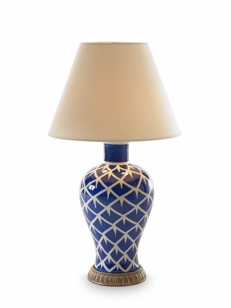 This vibrantly painted “chicken feather” design was inspired by captivating pottery from Peru, and enhances the fluid lines of this ceramic lamp.