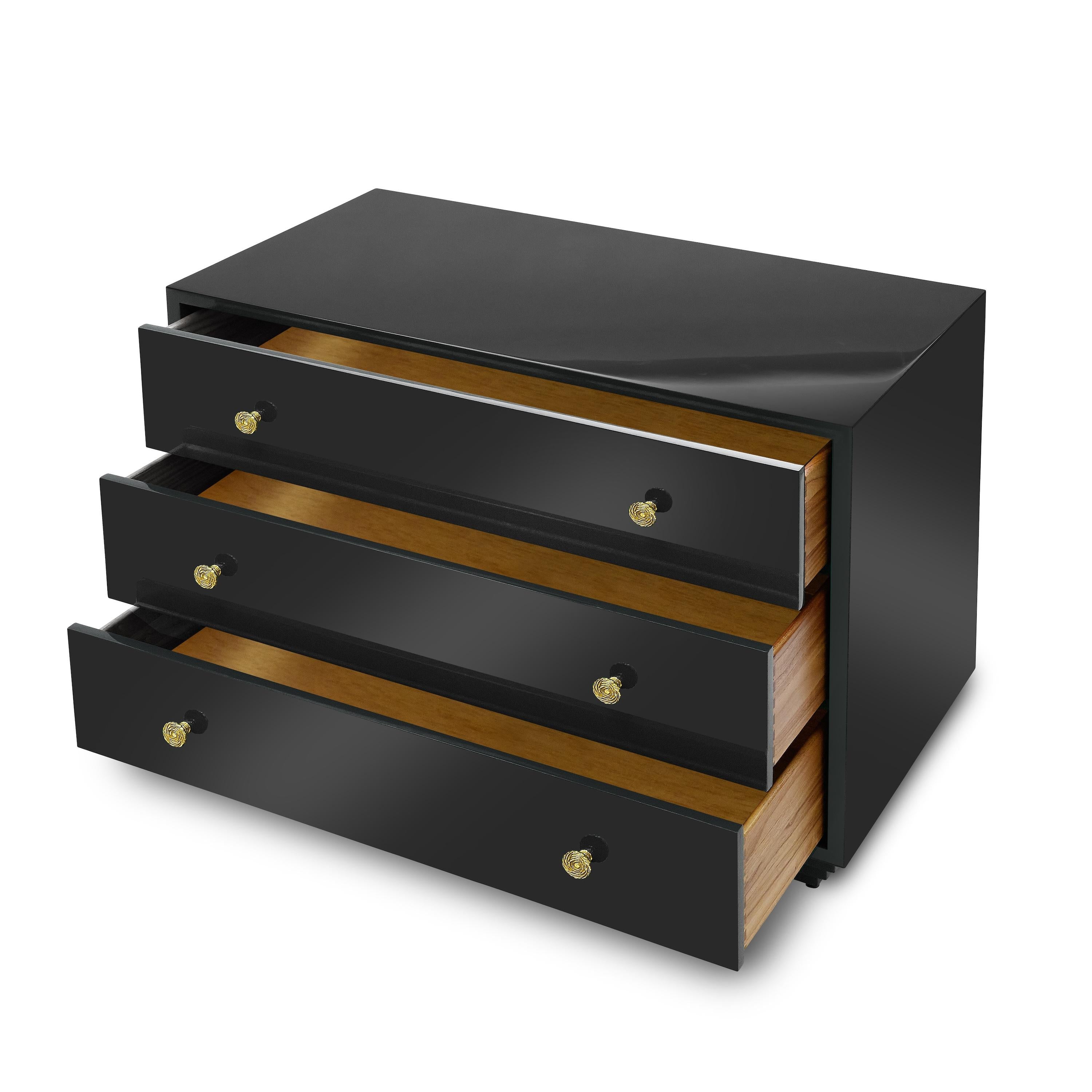 The brilliant, glossy painted finish shows off the clean silhouette of this three-drawer chest, which rests atop an inverted stepped plinth. Bunny’s fondness for early twentieth-century jewelry inspired the gleaming brass pulls--polished