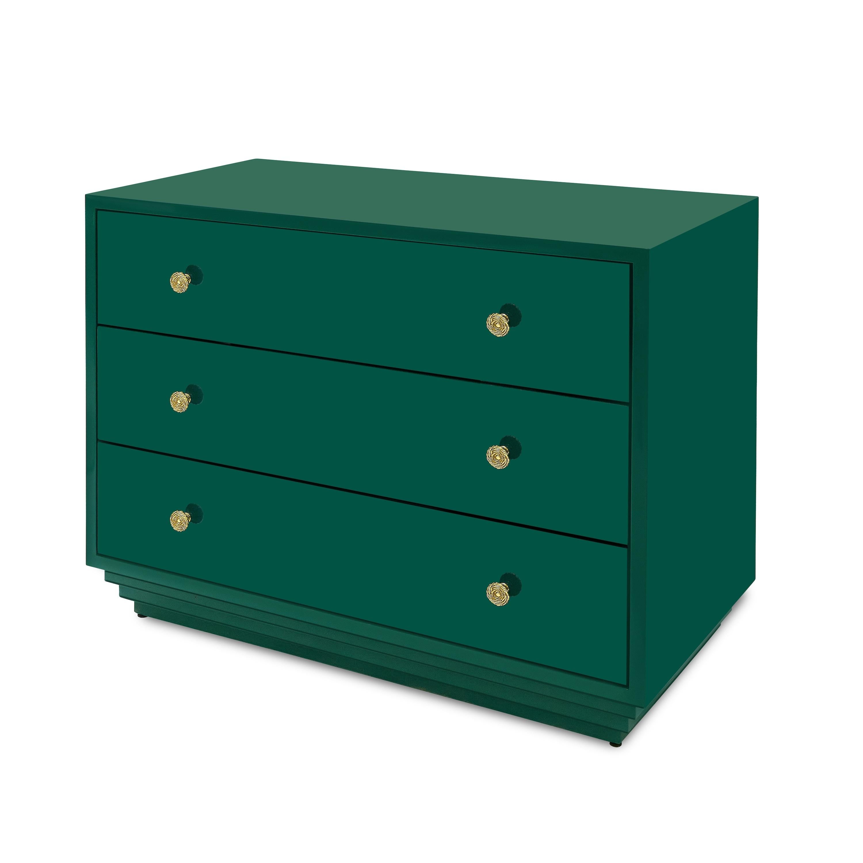 The brilliant, glossy painted finish shows off the clean silhouette of this three-drawer chest, which rests atop an inverted stepped plinth. Bunny’s fondness for early twentieth-century jewelry inspired the gleaming brass pulls--polished