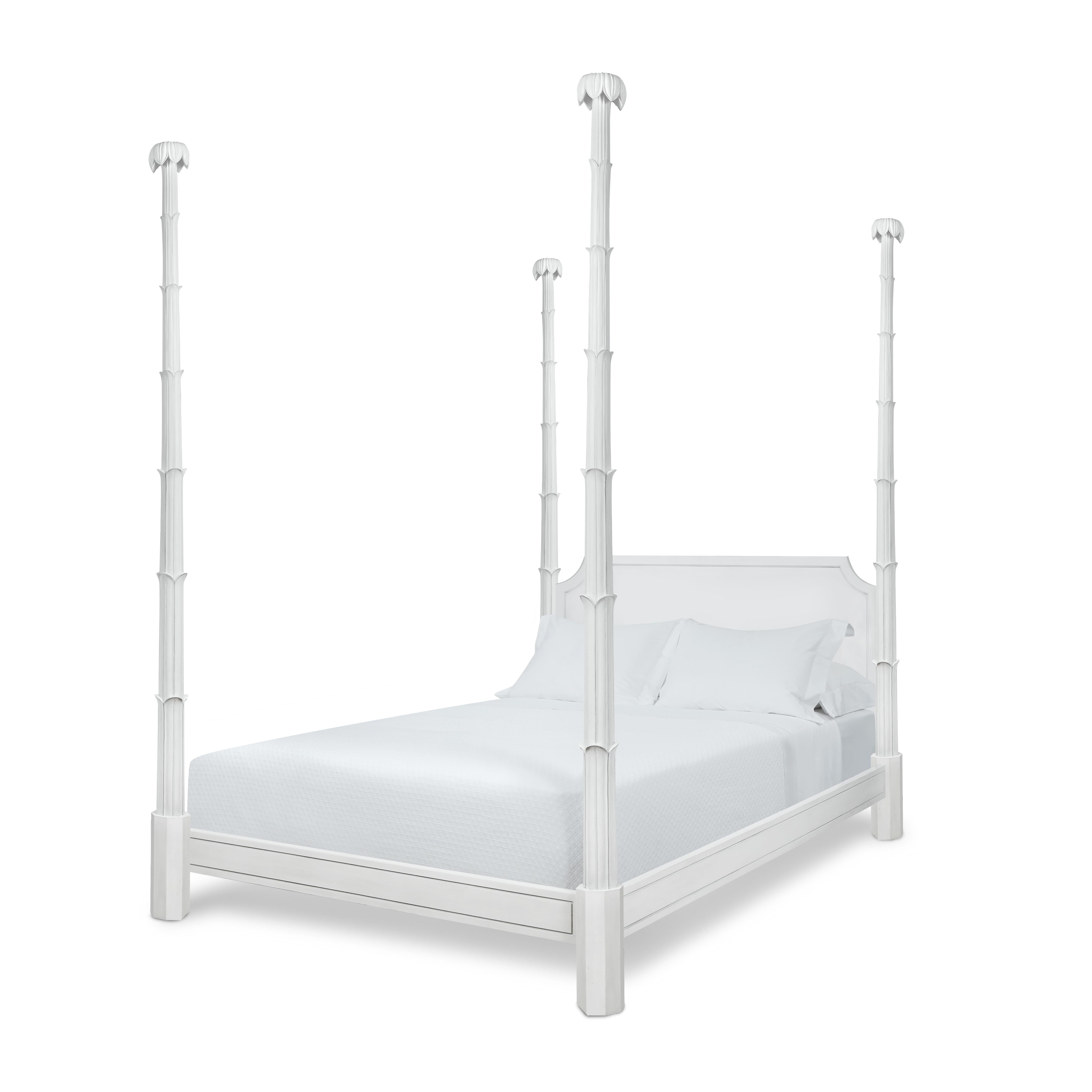 The Keller bed celebrates the bold carving of the Hollywood Regency style, and features carved, septet foliated posts crowned with petals. Its sophisticated, notched headboard is set off by the serene white painted finish, which also covers the