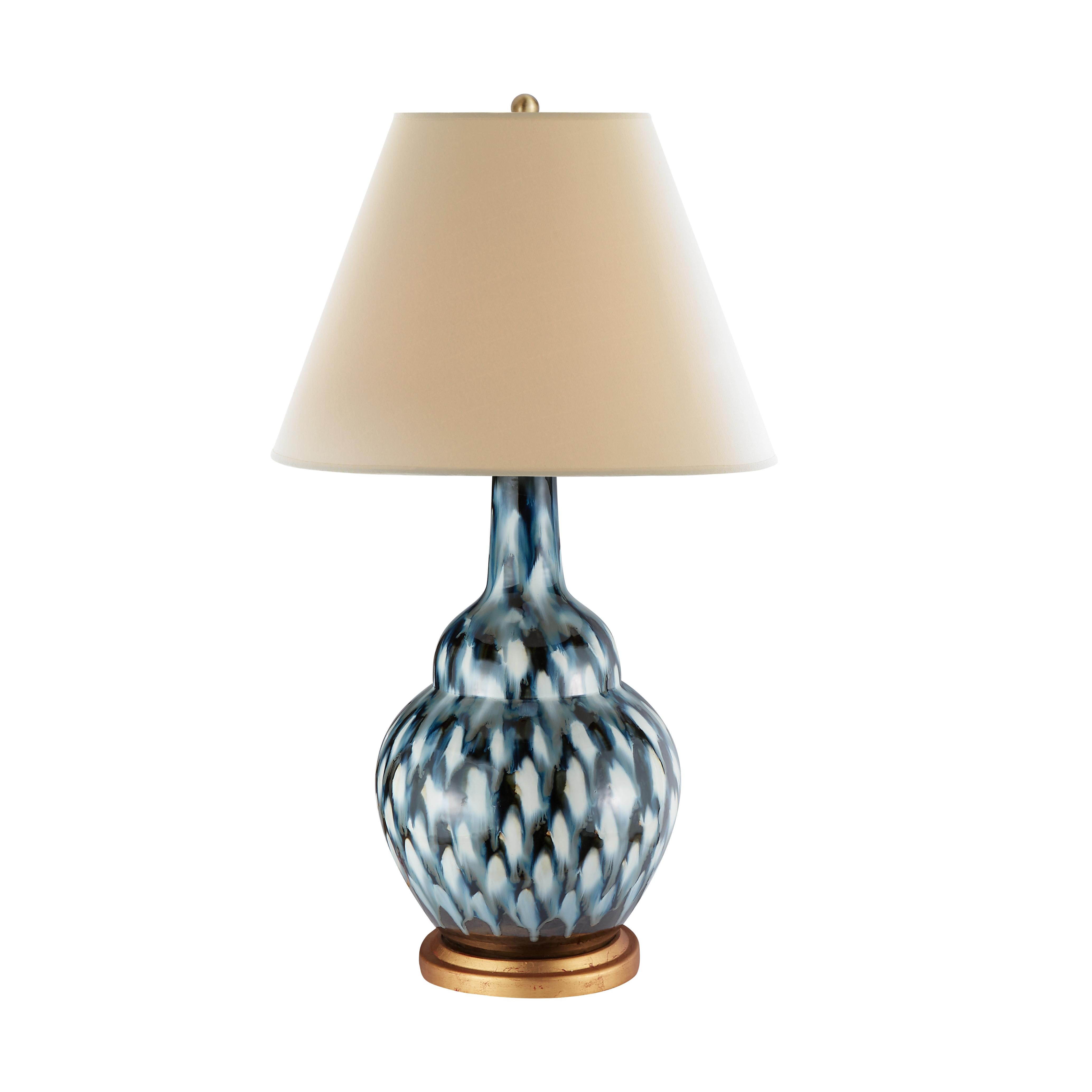 The classical silhouette of our Pheasant Feather lamp adds a graceful, subdued ambiance to any side table. The lamp’s ceramic vase is hand-painted in deep blue tones before a final glazing and firing to produce this stunning allover pattern. It is
