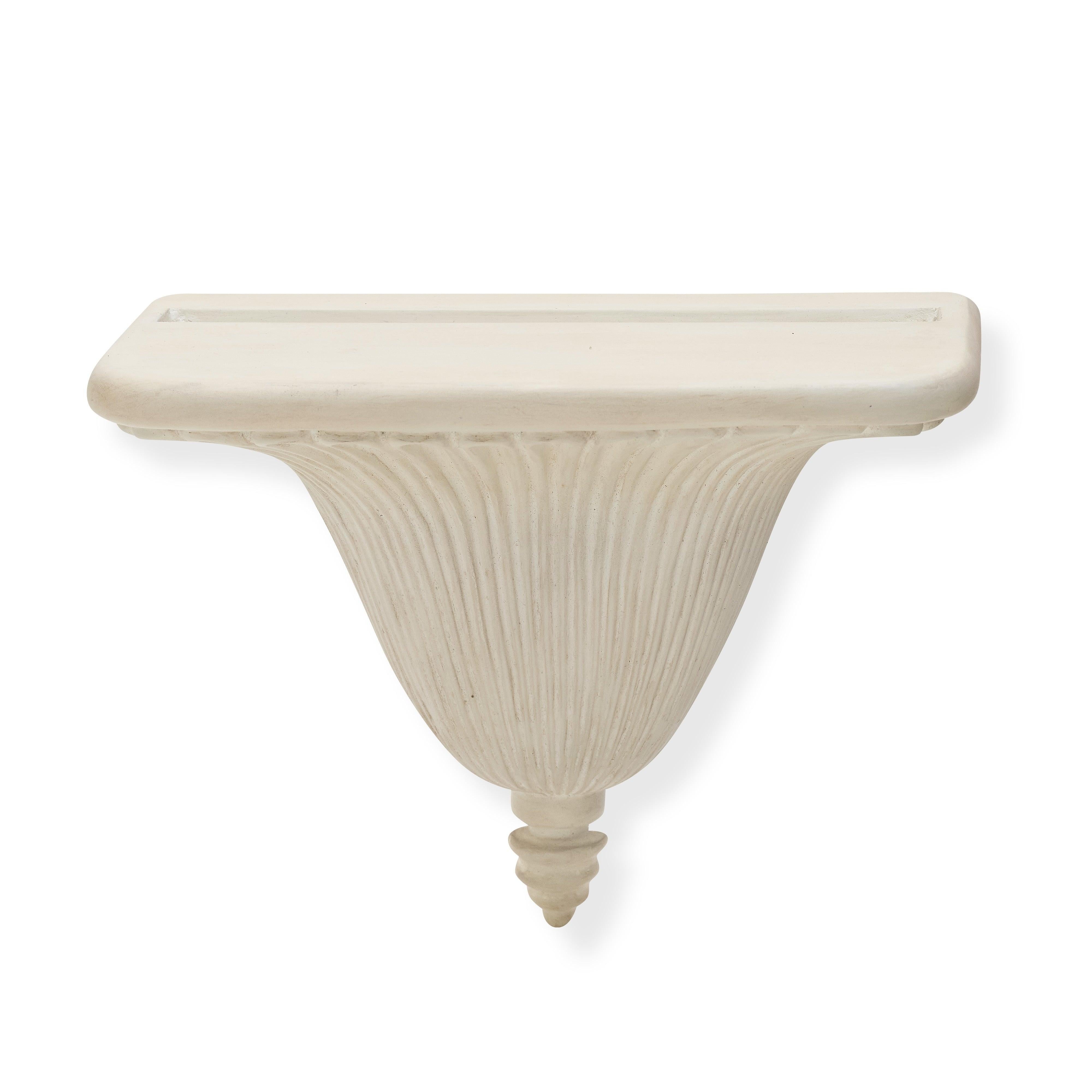 Nuestro soporte de pared Regency presenta elegantes detalles estriados que se abren en abanico desde un remate central, que recuerda a la arquitectura clásica. El acabado blanco tiza y la forma sutilmente curvada confieren ligereza al diseño.