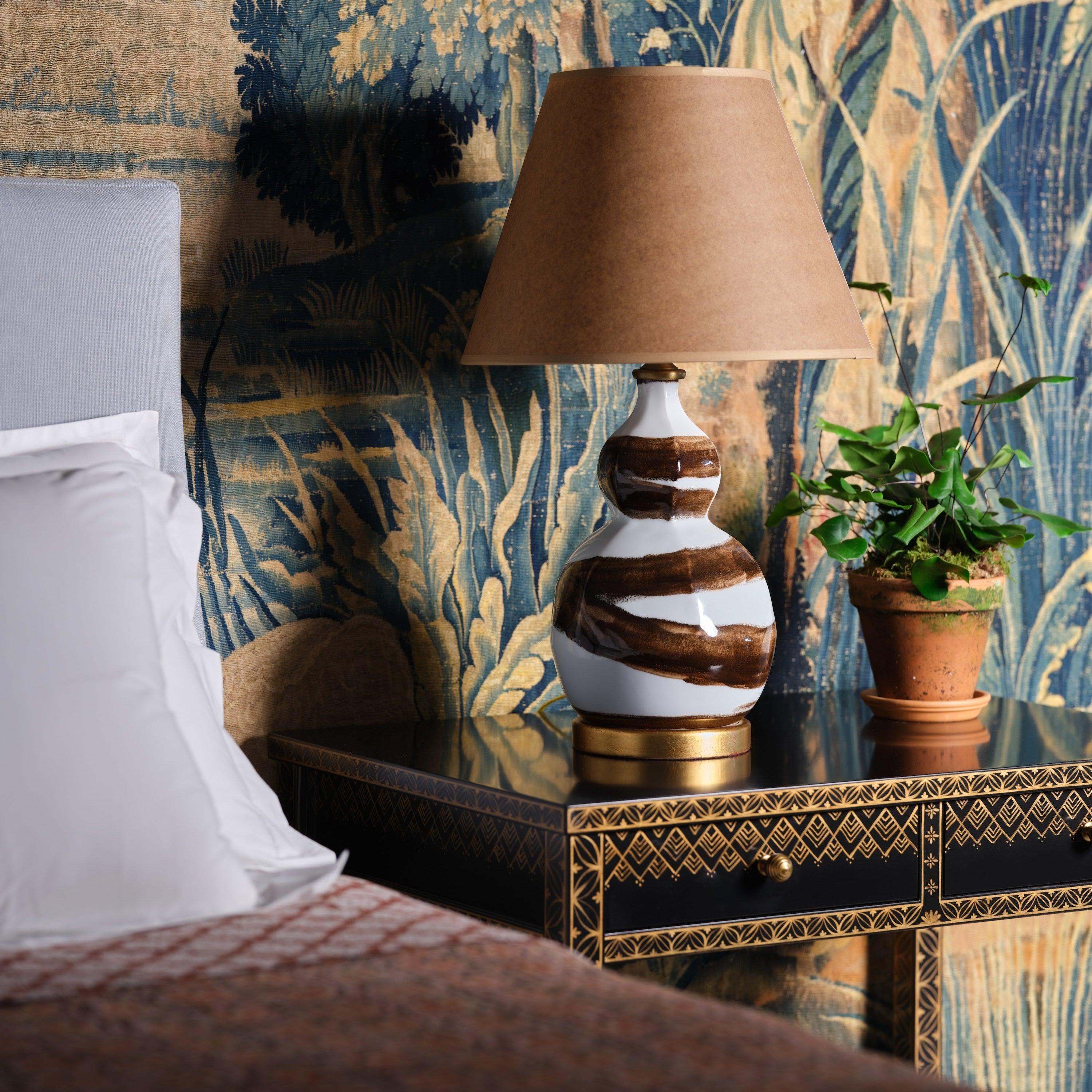 Our signature brushstroke design is now available on a smaller size lamp. A gently faceted double-gourd shape sits atop a gold gilt base.

8” Diameter x 24”H Overall
7” Diameter Base

Lampshade not included.
Recommended lampshade size:
15
