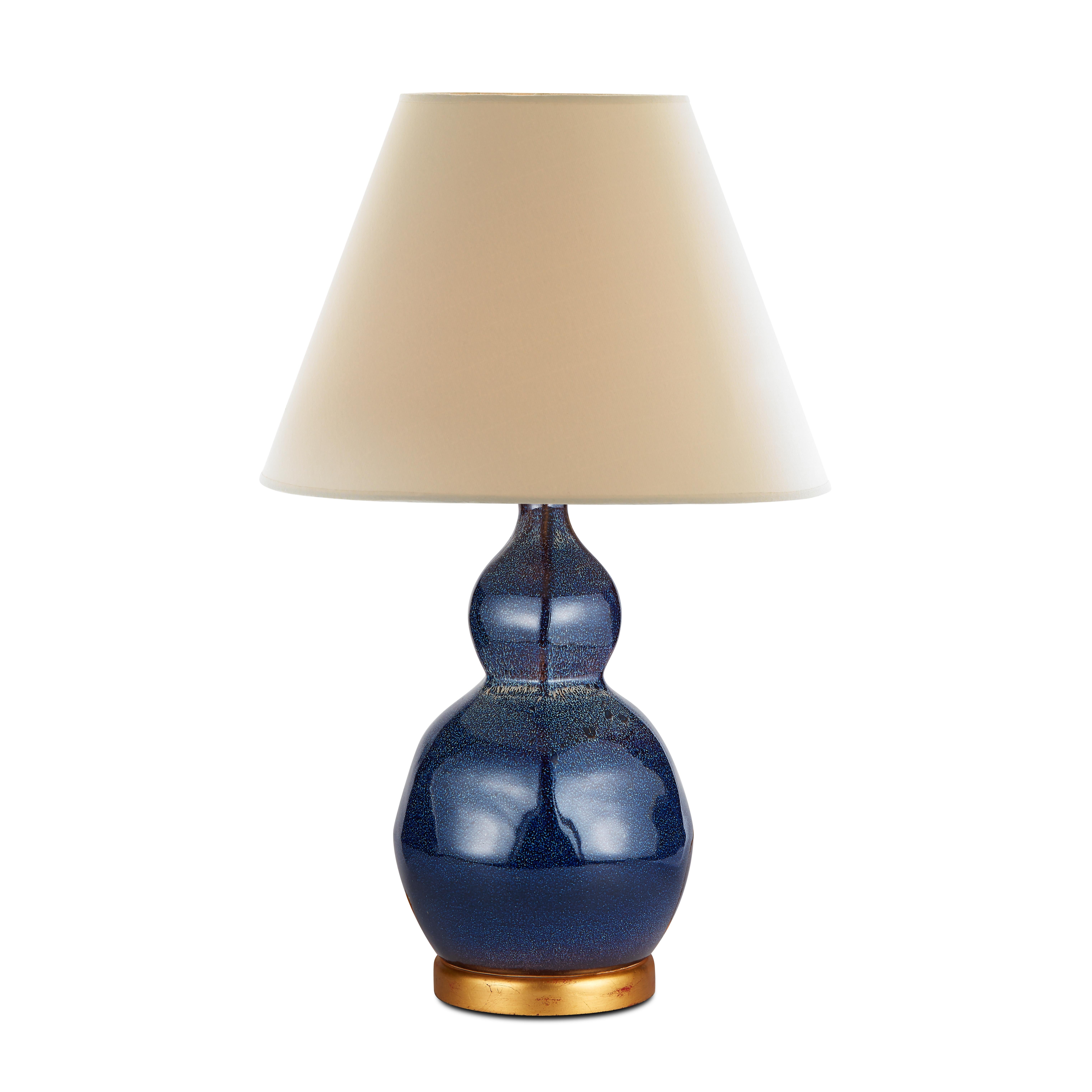 The influence of traditional Jun ware can be seen in the midnight blue glaze of our Small Speckled Lamp. Dotted with small white spots, a thick blue glaze smoothly covers the lamp’s gently faceted double-ground shape, which sits atop a smooth gold