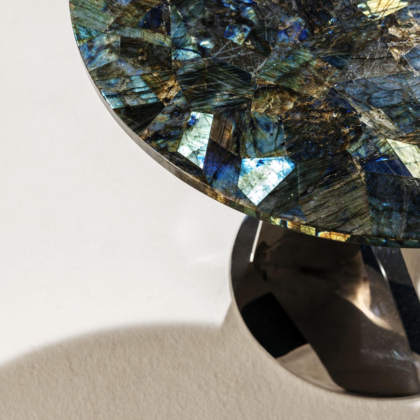 A stupefying mosaic of labradorite tiles evocative of magical atmospheres is the focal element of this luxurious side table. Extending from a coordinated disk base, a couple of sheets slightly curve and twist, creating a sculptural base in