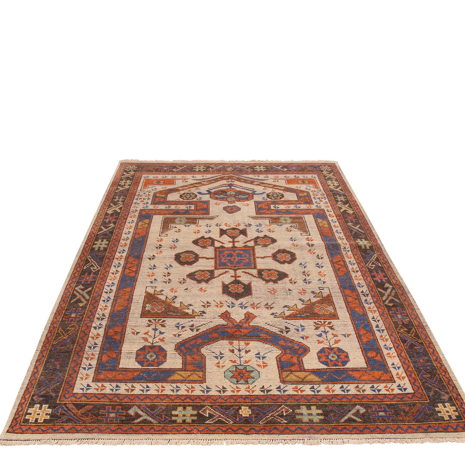 Hand knotted in India, this wool prayer rug is part of Rug & Kilim’s premier Burano collection, embracing an iconic Traditional Design with revitalized tangerine and burgundy red, beige, and blue colorways complementing the very fluid intricacies of