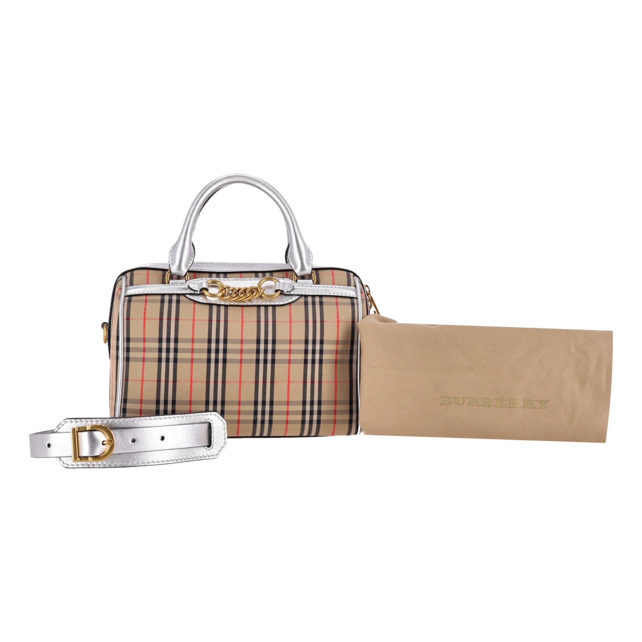 Burberry 1983 Nova Check Chain Link Bowling Bag

Iconic check pattern bag with metallic silver leather trim, top carry handles and removable shoulder strap.

Gold chain link trim to front and hardware. Rrp Approx. £1,250

Size - Height 17cm, Width