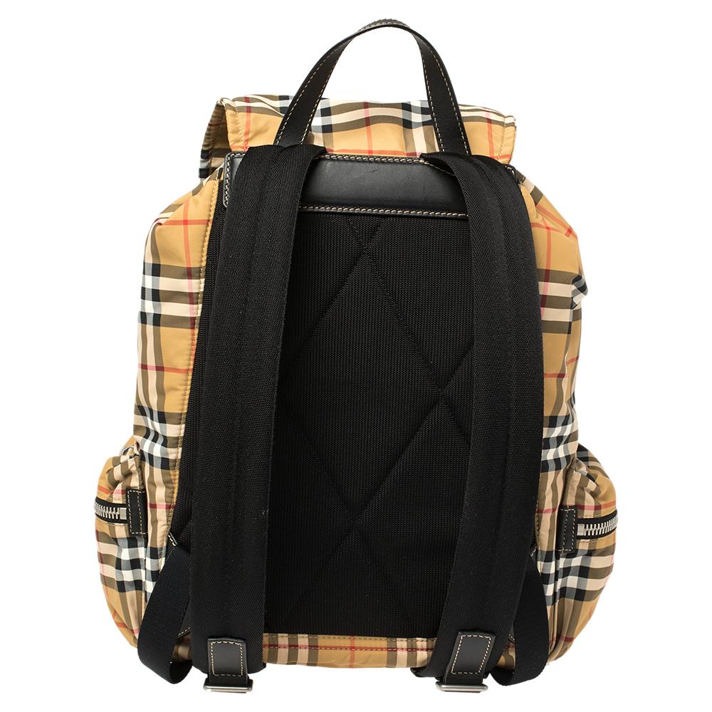 A timeless backpack like this one from Burberry is an essential addition to your closet. Made from Vintage Check coated nylon and leather, it is an ideal travel companion because of the spacious interior. The backpack is complete with two side