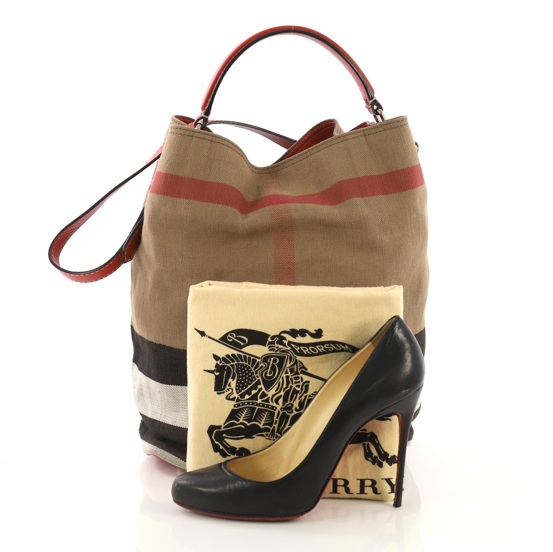 This Burberry Ashby Handbag House Check Canvas Medium, crafted in multicolor house check canvas and red leather, features a single looped leather handle, and gold-tone hardware. Its magnetic snap closure opens to a red leather interior. **Note: Shoe