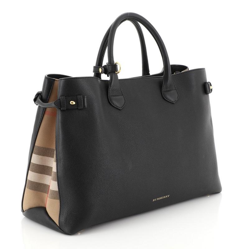 This Burberry Banner Convertible Tote Leather and House Check Canvas Large, crafted in black leather and house check canvas, features dual rolled handles, stamped Burberry logo, house check canvas side panels, protective base studs and gold-tone