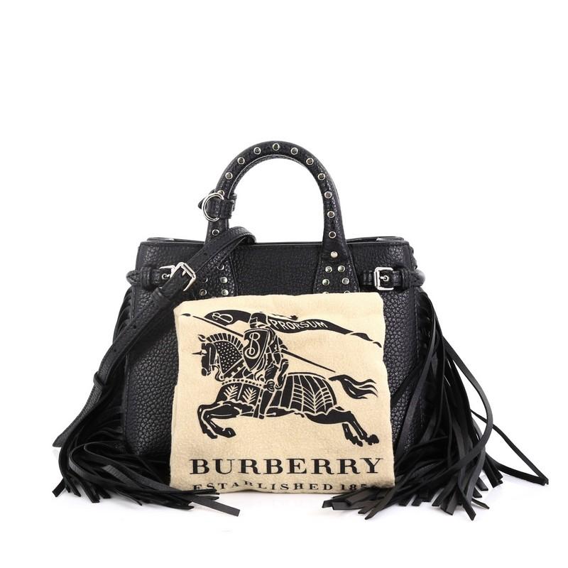 This Burberry Banner Convertible Tote Studded Leather with Fringe Baby, crafted in black studded leather, features dual rolled handles, fringe detailing, and silver-tone hardware. Its magnetic snap closure opens to a check fabric interior with side