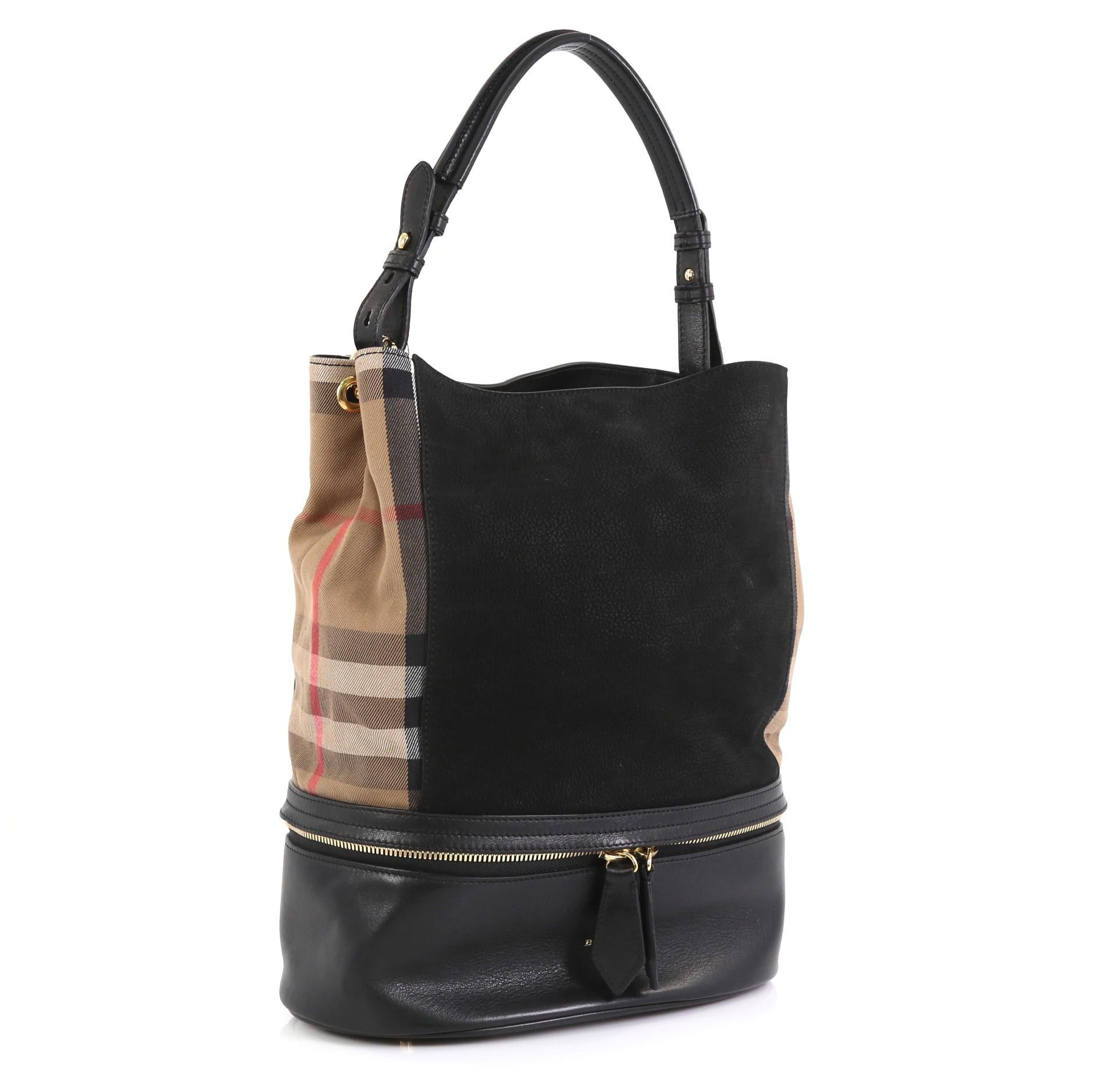 This Burberry Beckett Bucket Bag Nubuck with House Check Canvas Medium, crafted from black nubuck with Burberry House Check sides and a leather base, features an adjustable padded top handle, zip-around bottom compartment with embossed logo,