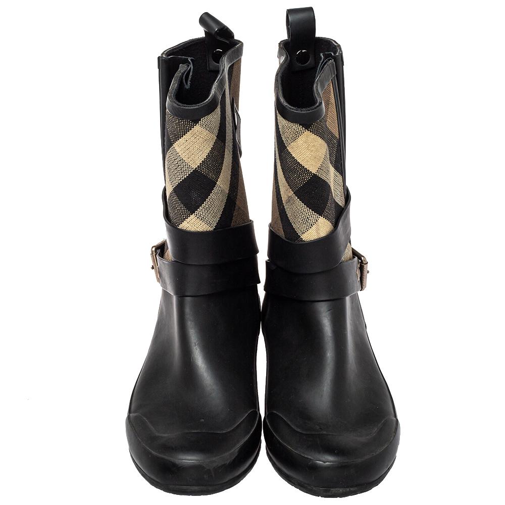 Feel warm and cozy when you wear these boots from the fashion house of Burberry. The beige & black check canvas Y rubber exterior is coupled with buckle detailing. Accented with fabric lining and rubber soles.

