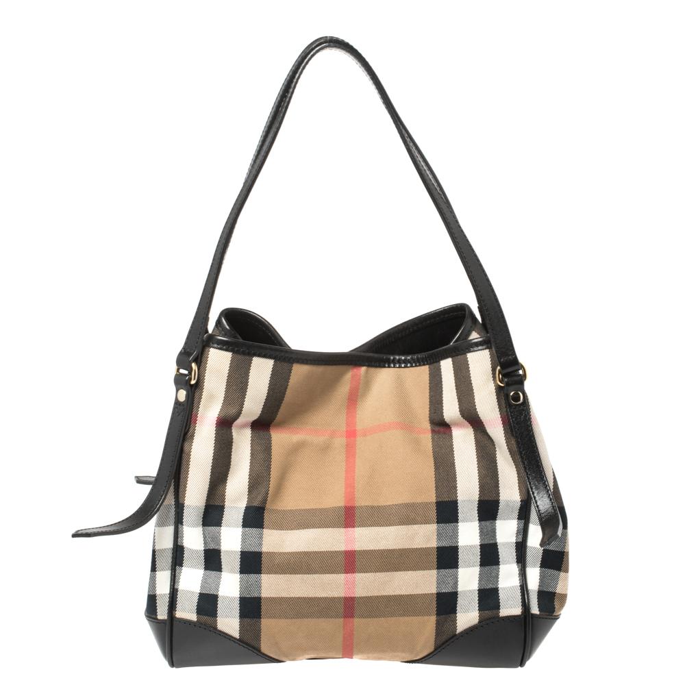 This Canterbury tote from Burberry is crafted with their signature House Check fabric and leather. It comes with a flat handle, protective metal feet, and a canvas-lined interior that can hold all your daily necessities. Simple in design, the bag is