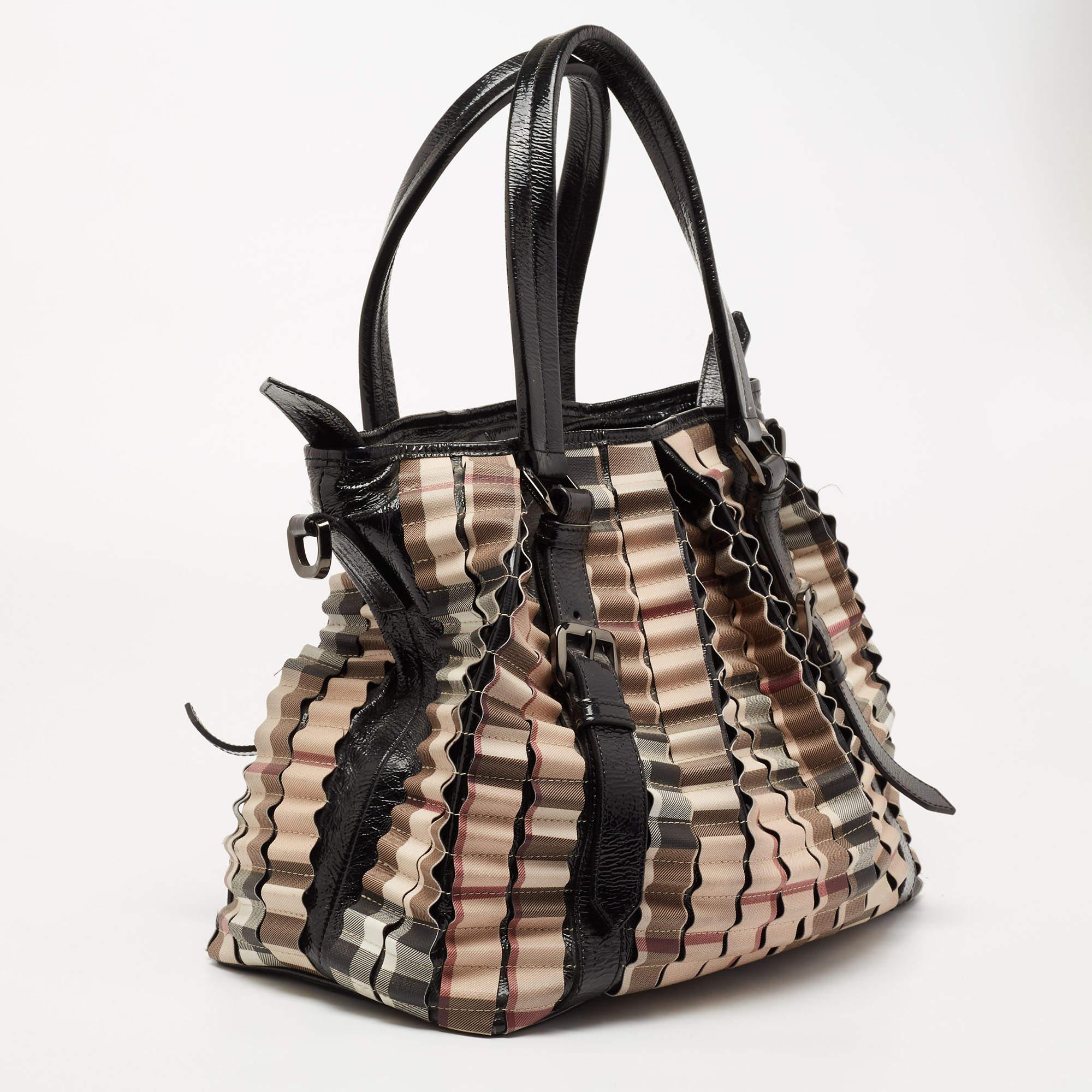 The tote from the house of Burberry features the iconic House Check PVC as pleats running all over the bag. Held by two handles and equipped with a spacious fabric interior, the bag is a great option to carry for work, shopping, or travel.

