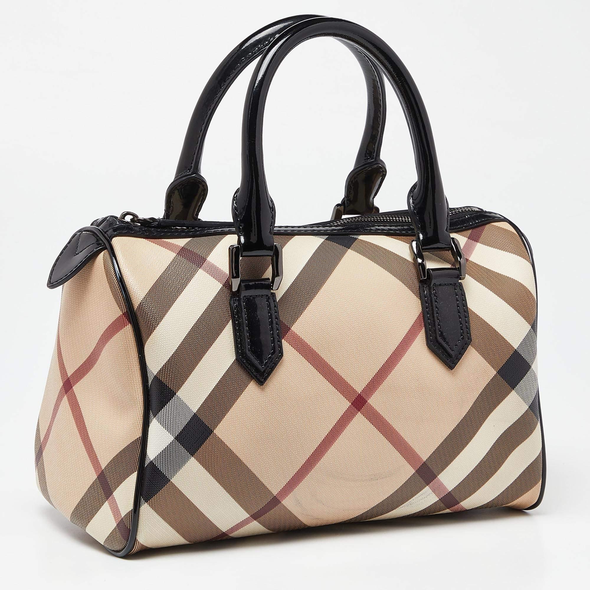 Spacious and classy, this Chester Boston bag is from Burberry. It has been crafted from their signature Nova check PVC and accented with leather trims and black-tone hardware. It is equipped with a well-sized fabric interior and two handles.


