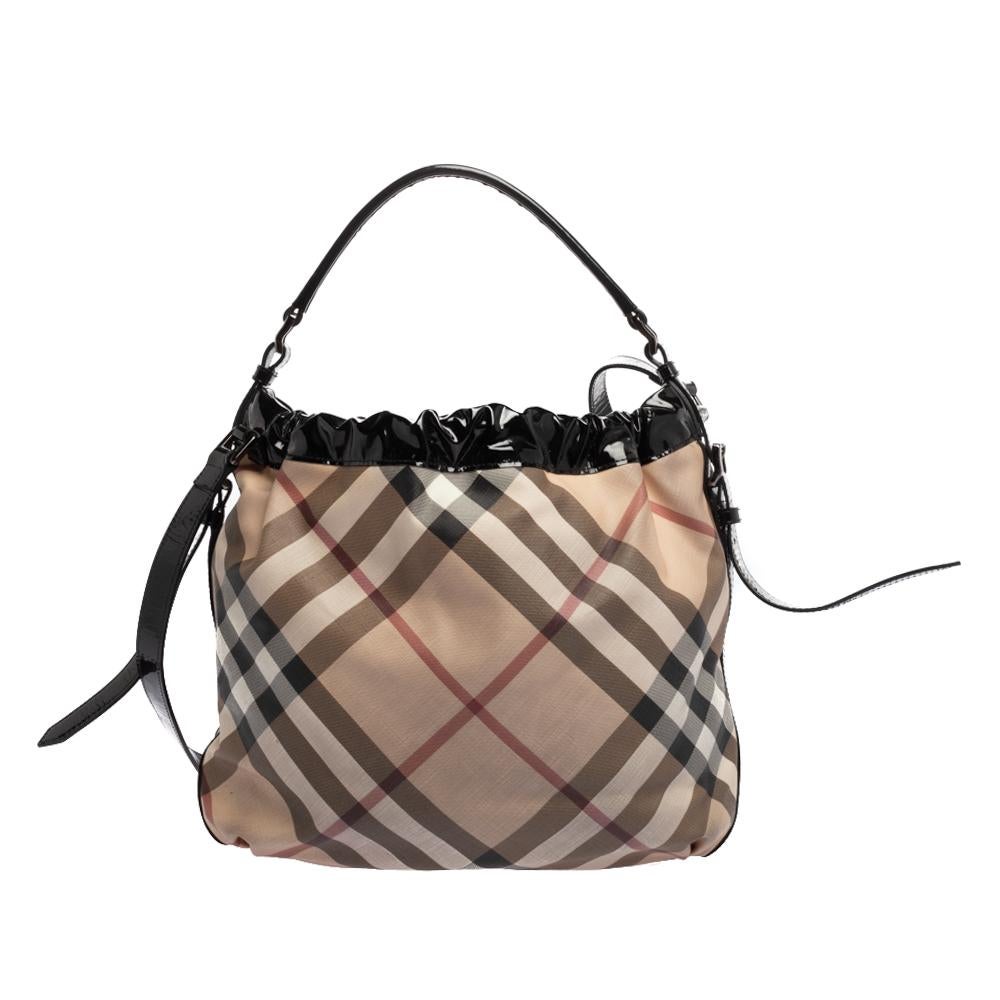 Owning Burberry’s iconic Novacheck PVC bag is an absolute must for all fashionistas. This stylish hobo is detailed with patent leather trim and is designed with two front pockets with buckle closures. It features a single top handle and an