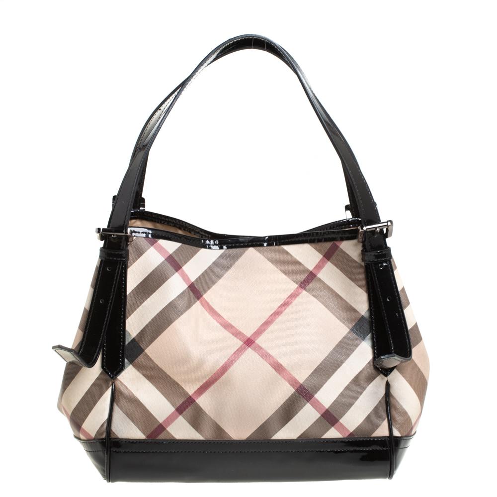This Canterbury tote from Burberry is crafted from Nova Check PVC and enhanced with patent leather. It comes with dual flat handles, protective metal feet, and a spacious fabric-lined interior that can hold all your daily necessities. Simple in