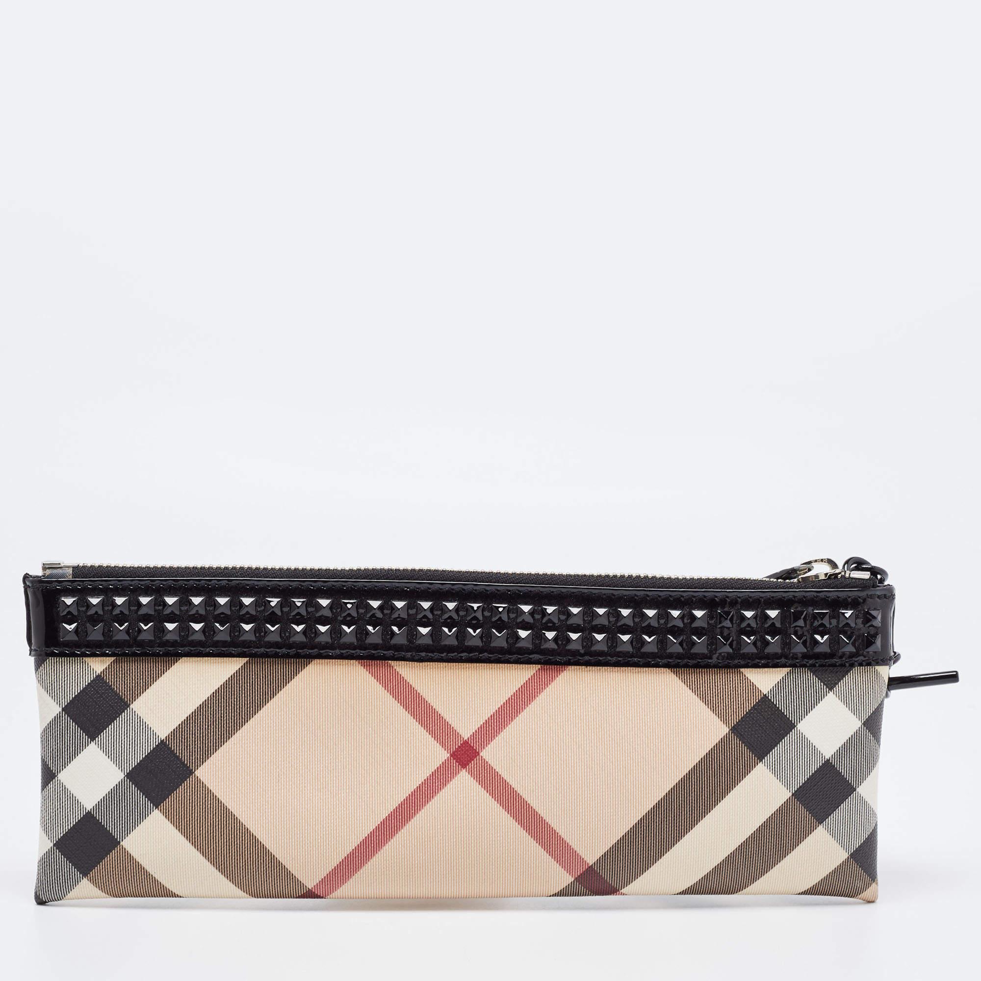 Have all eyes on you when you flaunt this stunner of a clutch by Burberry. Crafted from PVC and patent leather, it carries the signature Nova check on the exterior. The clutch is equipped with a wrist strap and an interior that will hold all your