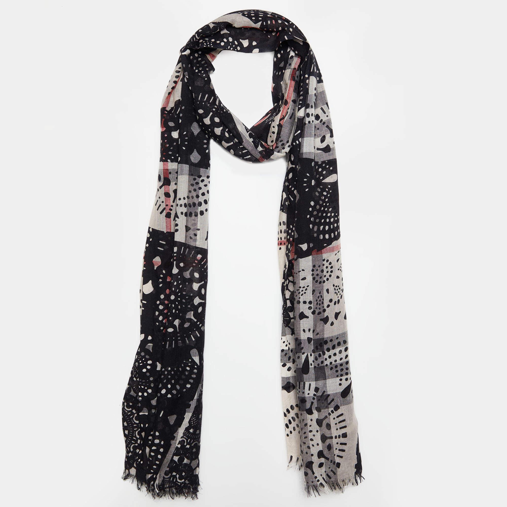 The Burberry shawl is a luxurious accessory featuring a timeless blend of beige and black hues. Crafted from a sumptuous combination of wool and silk, it showcases an intricate, elegant print, making it an exquisite addition to any outfit.

