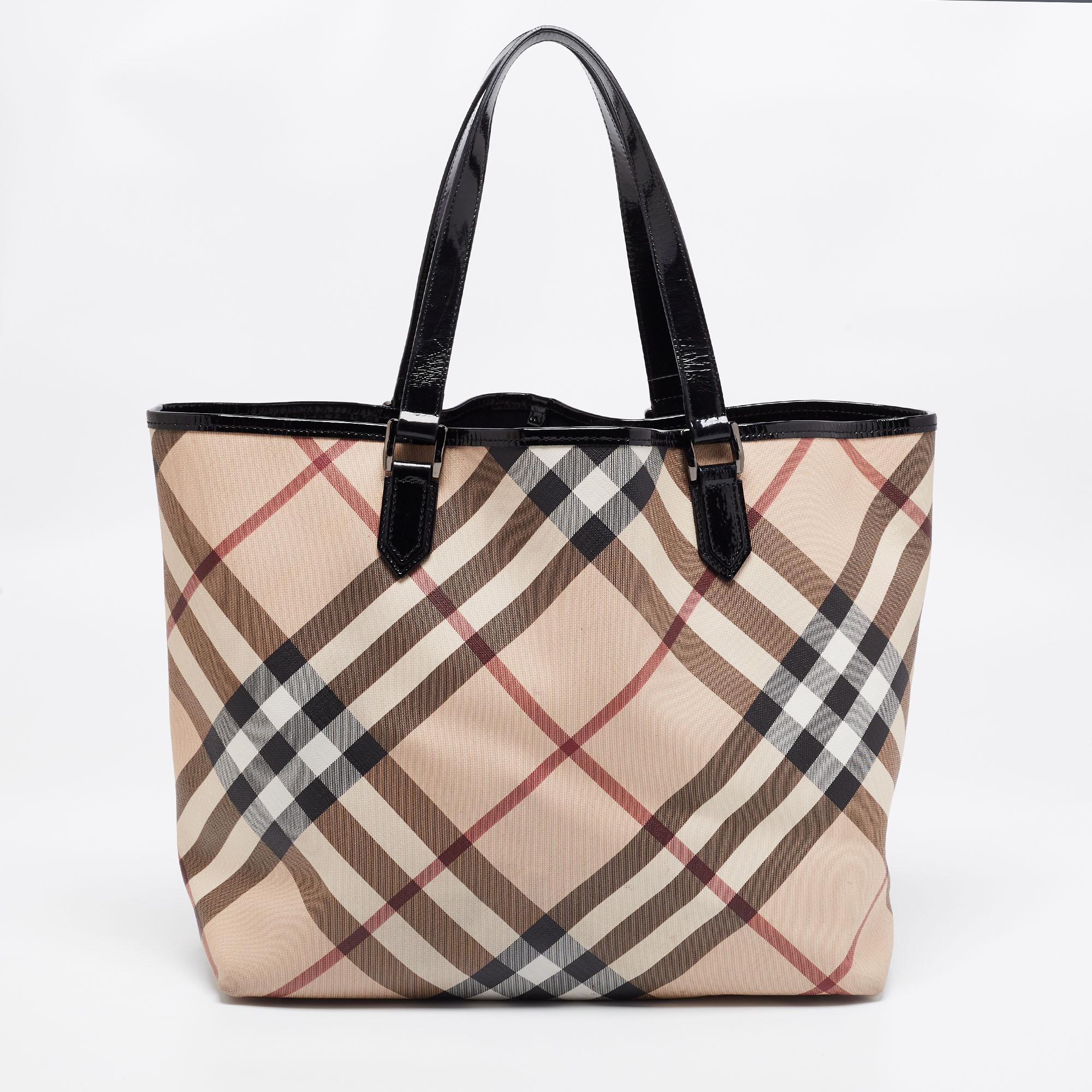 Burberry's Nickie tote is chic and smart. Crafted from PVC and styled with patent leather trims, it features two handles and protective metal feet at the bottom. It opens to a fabric-lined interior that has enough space for all your daily