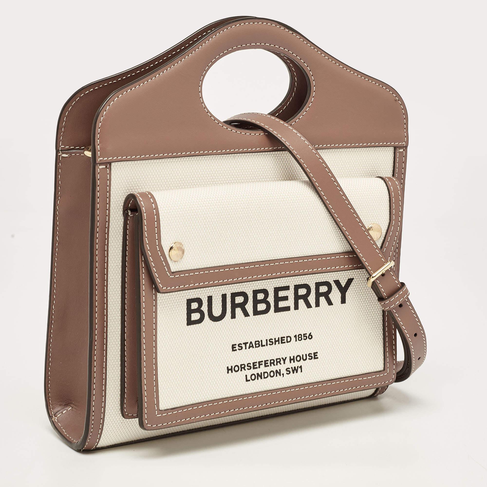 This stylish and durable tote by Burberry is perfect for everyday use. Crafted from canvas & leather, it comes in hues of beige & brown. it has in-built handles, a front flap pocket with the logo detail, spacious canvas interior and gold-tone