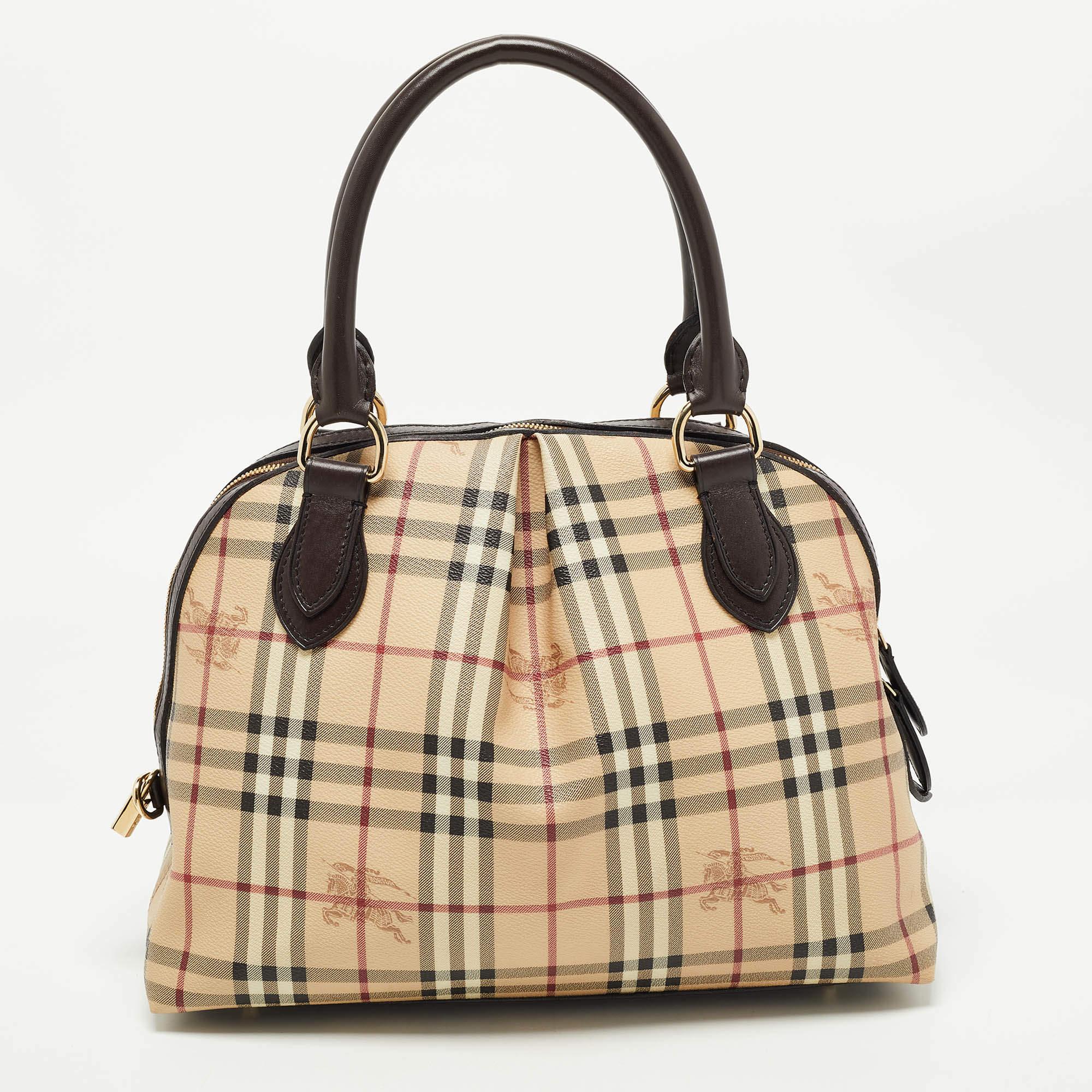 Spacious and captivating, this Thornley satchel is from Burberry. It has been crafted from their signature Haymarket check PVC and accented with leather trims and gold-tone hardware. It comes with dual-rolled handles and the zip-top closure opens to