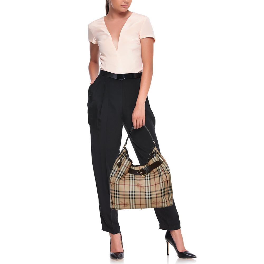 Diese Walden Hobo von Burberry ist aus PVC im klassischen Haymarket-Karo gefertigt und mit Lederbesätzen versehen. Der mit Canvas gefütterte Innenraum bietet Platz für die wichtigsten Dinge des Alltags:: und die Tasche ist mit einem einzigen Griff